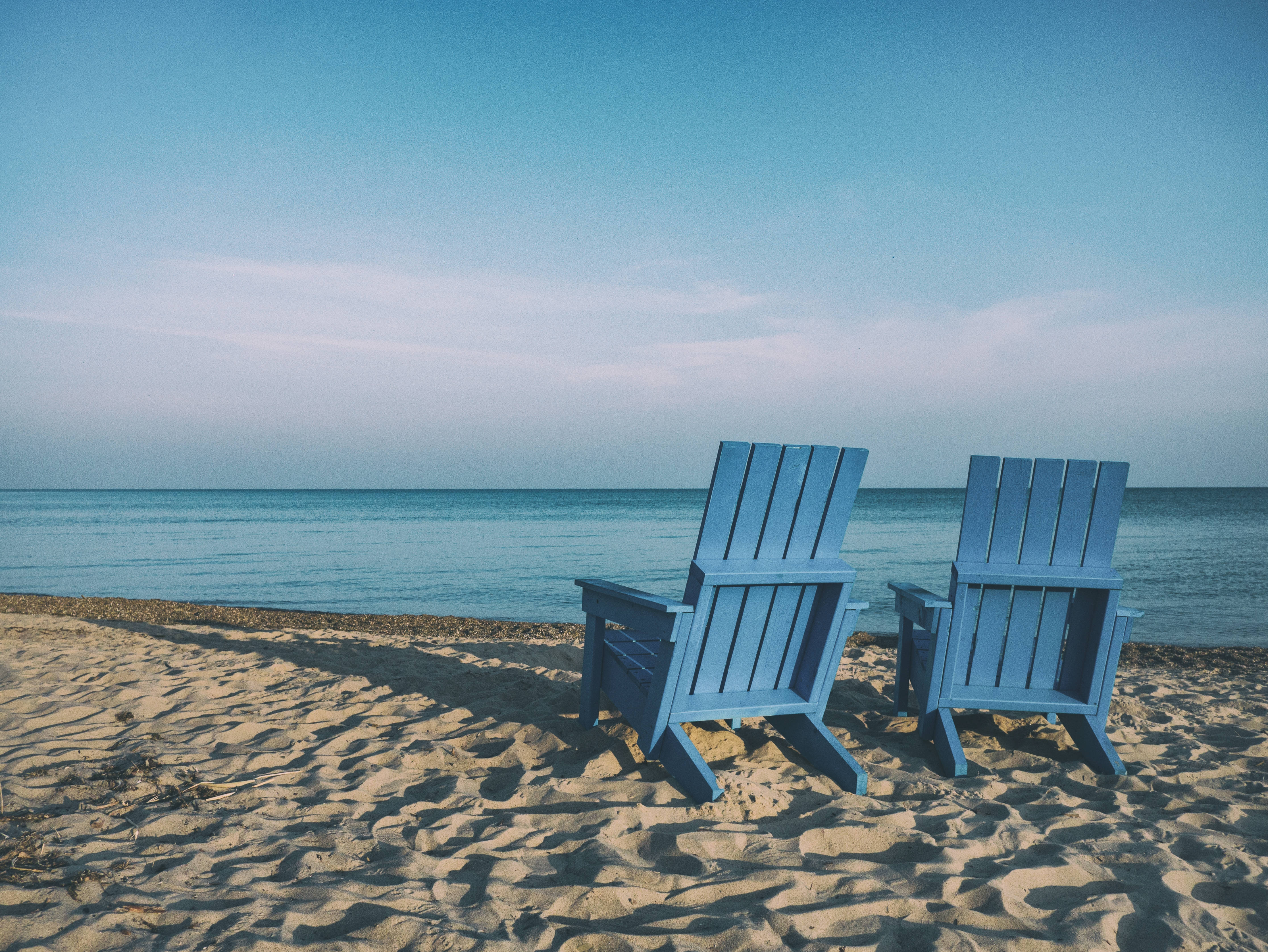 blue Adirondack chairs, sandy beach, calm ocean, 4K Desktop Wallpaper