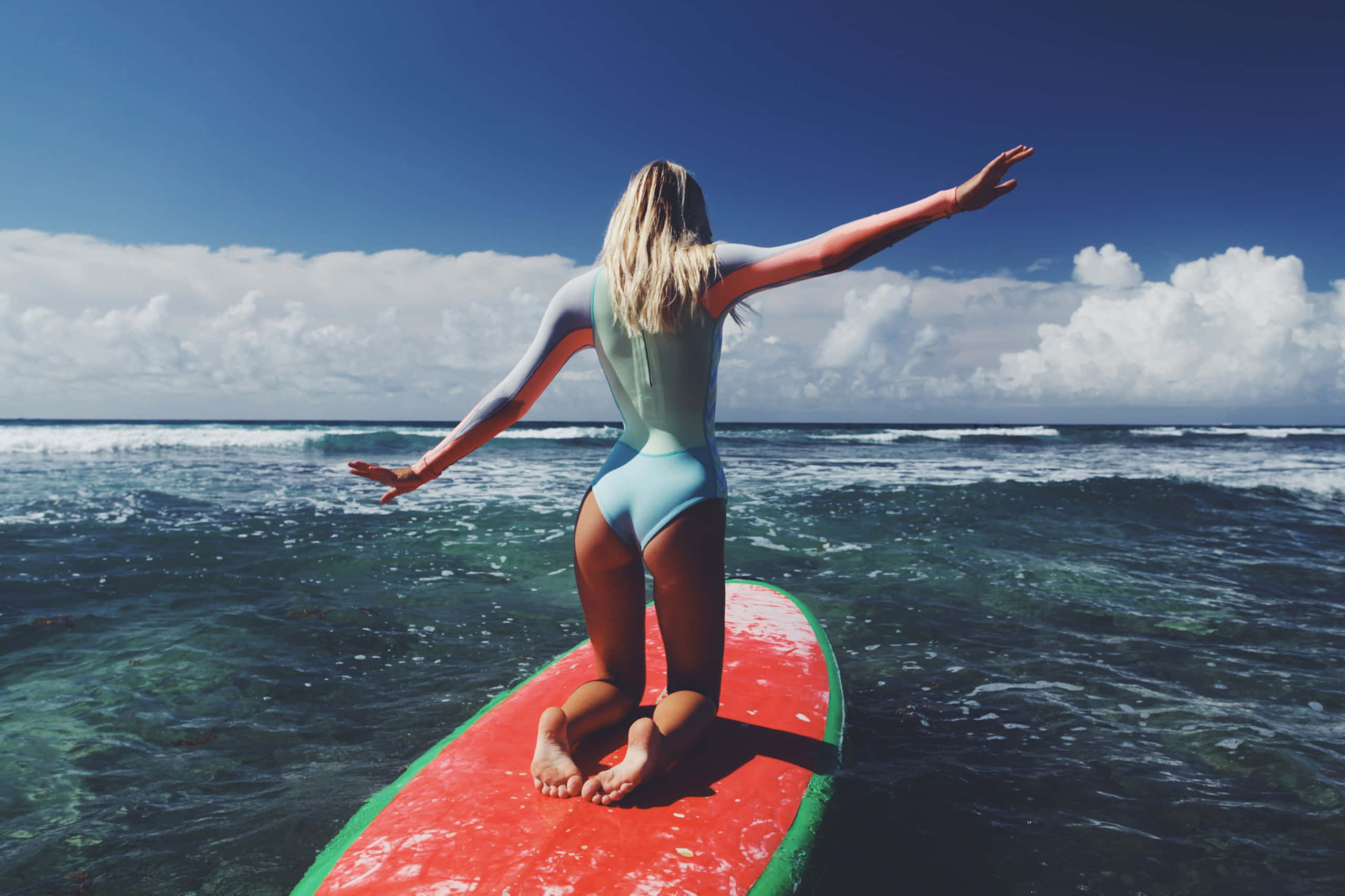 red surfboard, surfer girl, light blue wetsuit, 2K Desktop Wallpaper