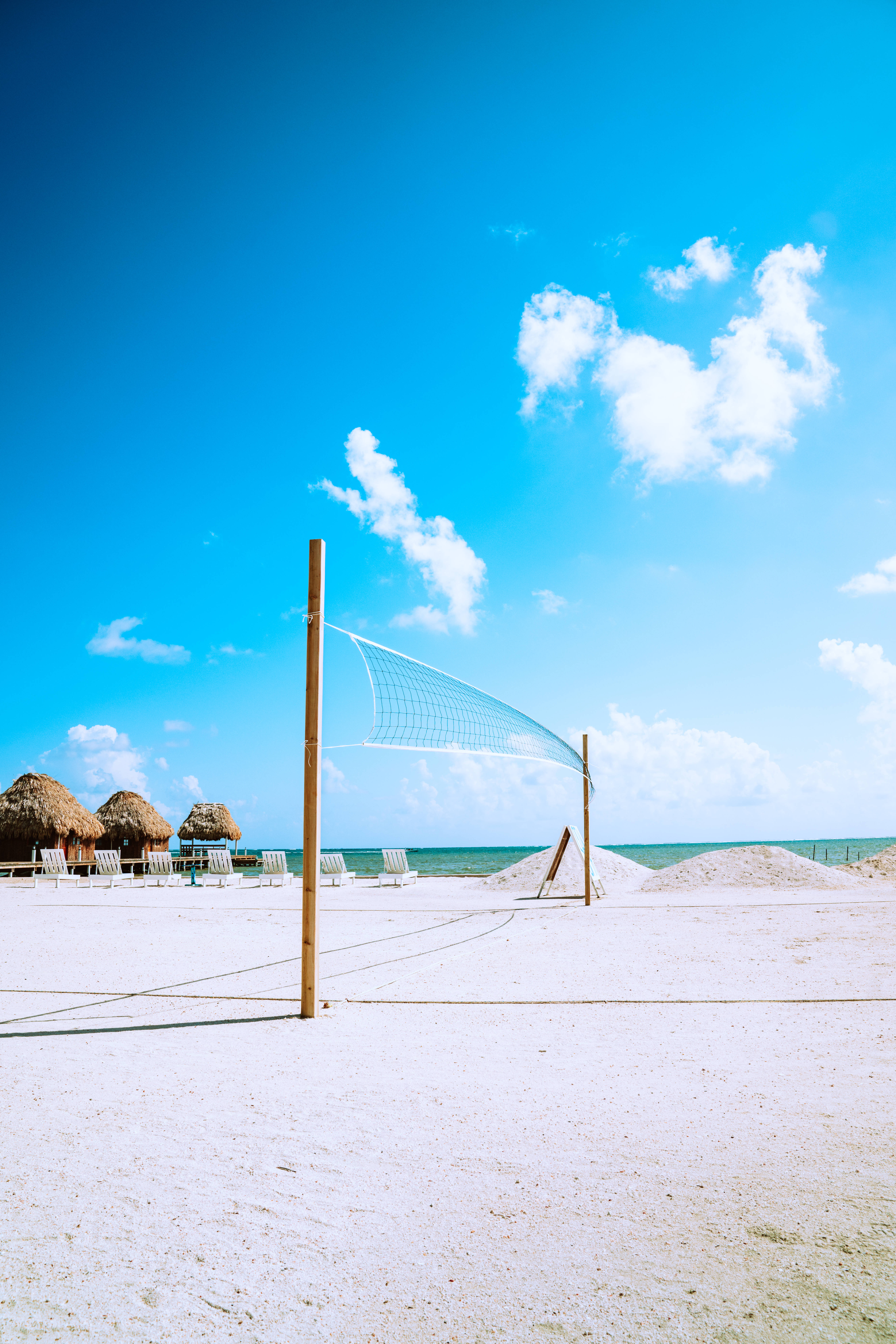 volleyball net, pristine white sandy beach, vibrant blue sky, 8K Phone Wallpaper