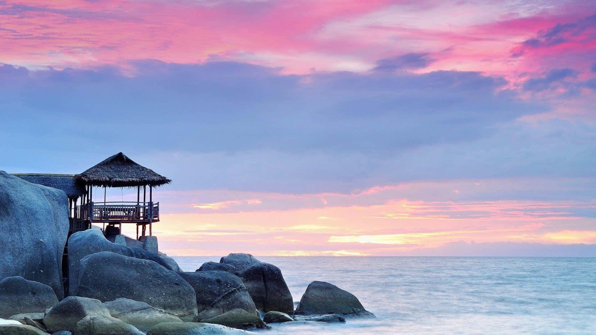 serene beach sunset hut, thatched-roof pavilion, giant boulders, Full HD Desktop Wallpaper