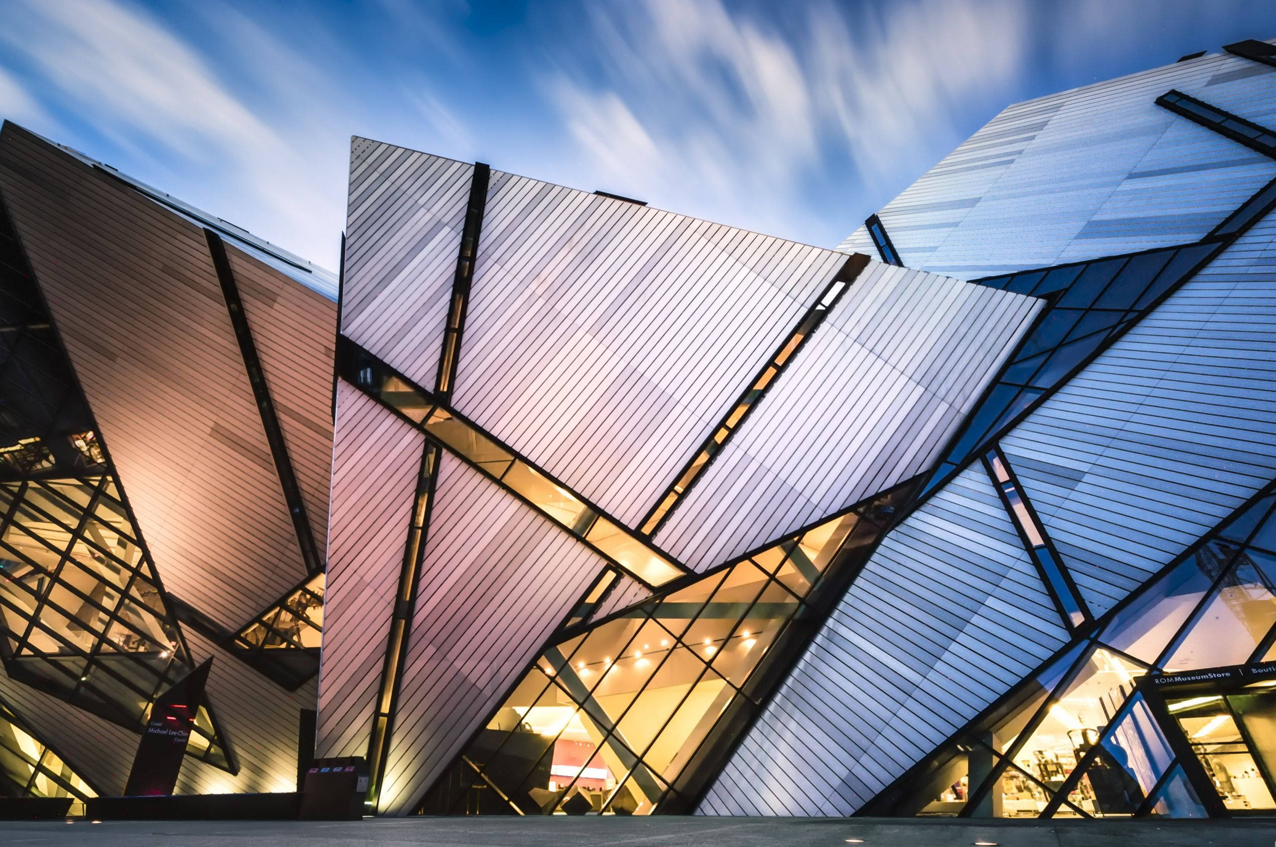 modern architecture, angular metallic panels, glowing interior lights, 2K Desktop Wallpaper