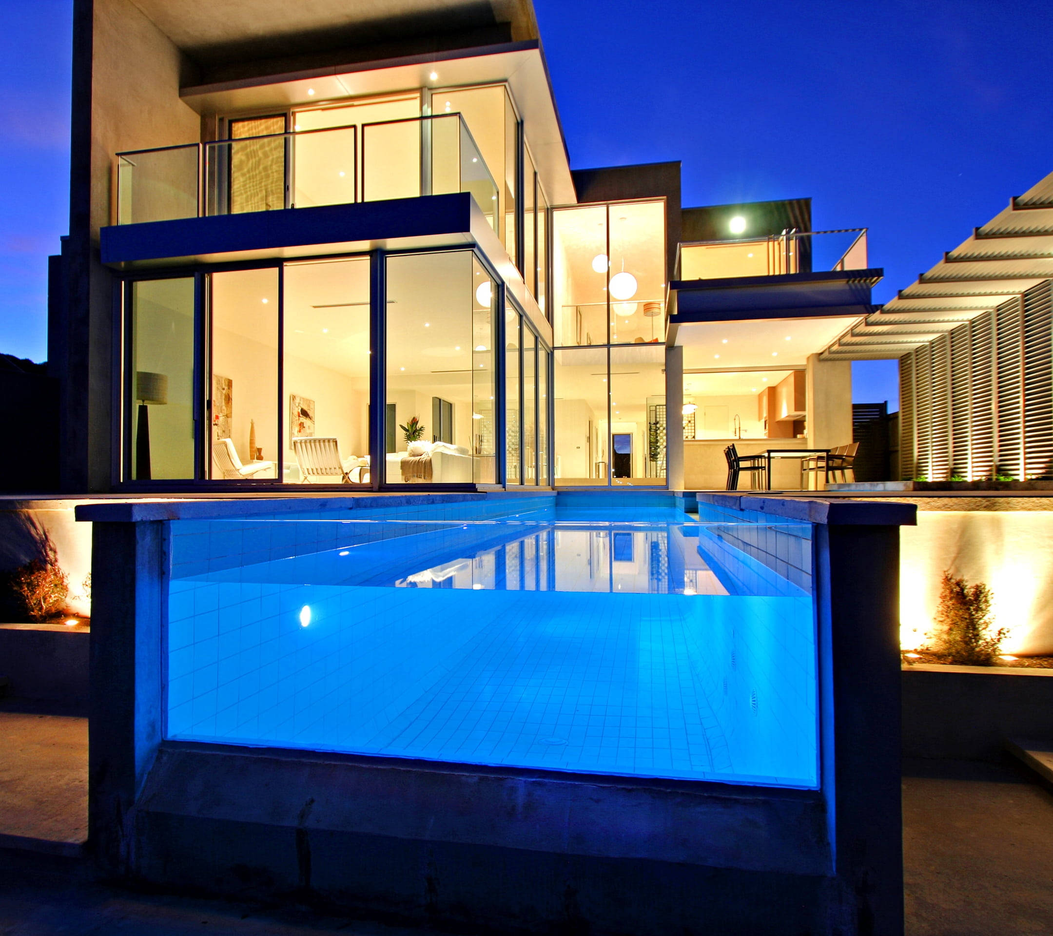modern glass house, glowing interior lights, vibrant blue infinity pool, Full HD Desktop Wallpaper