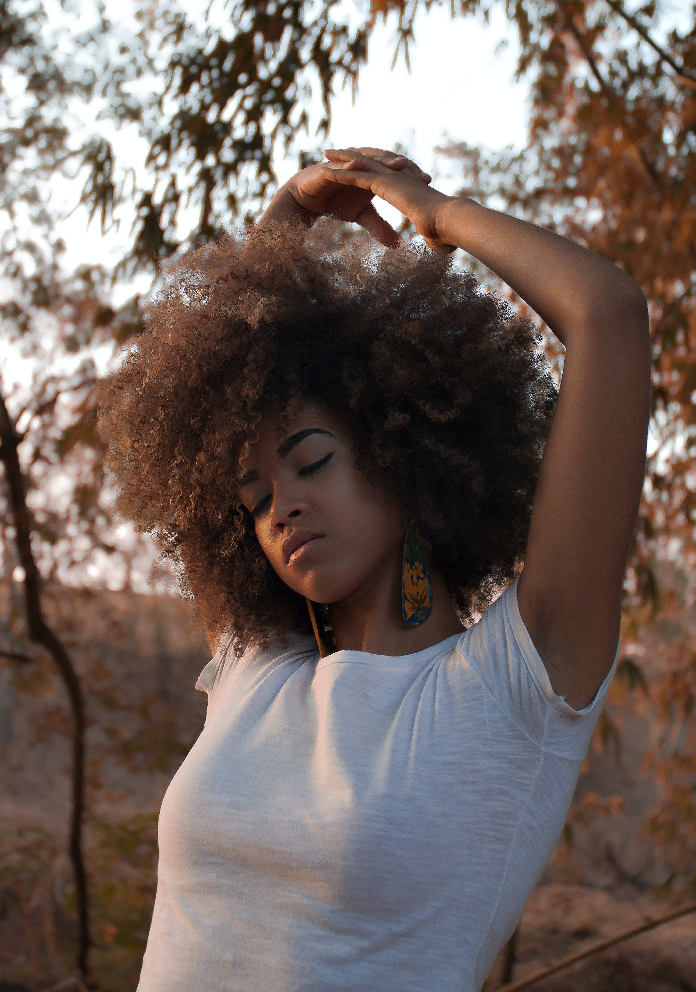 autumn trees, warm golden light, voluminous curly hair, 2K Phone Wallpaper