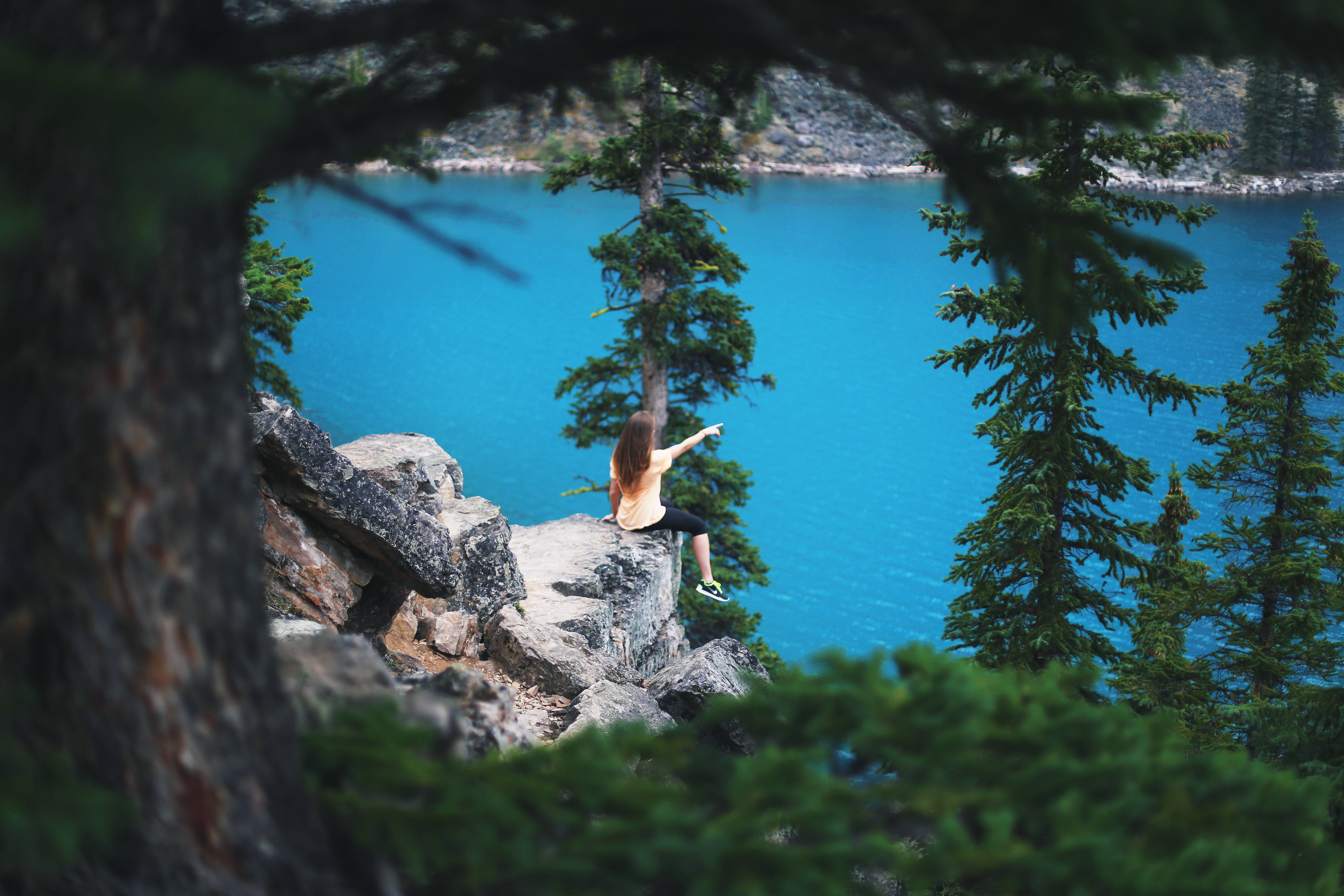 vibrant turquoise lake, evergreens, rocky cliff edge, 5K Desktop Wallpaper