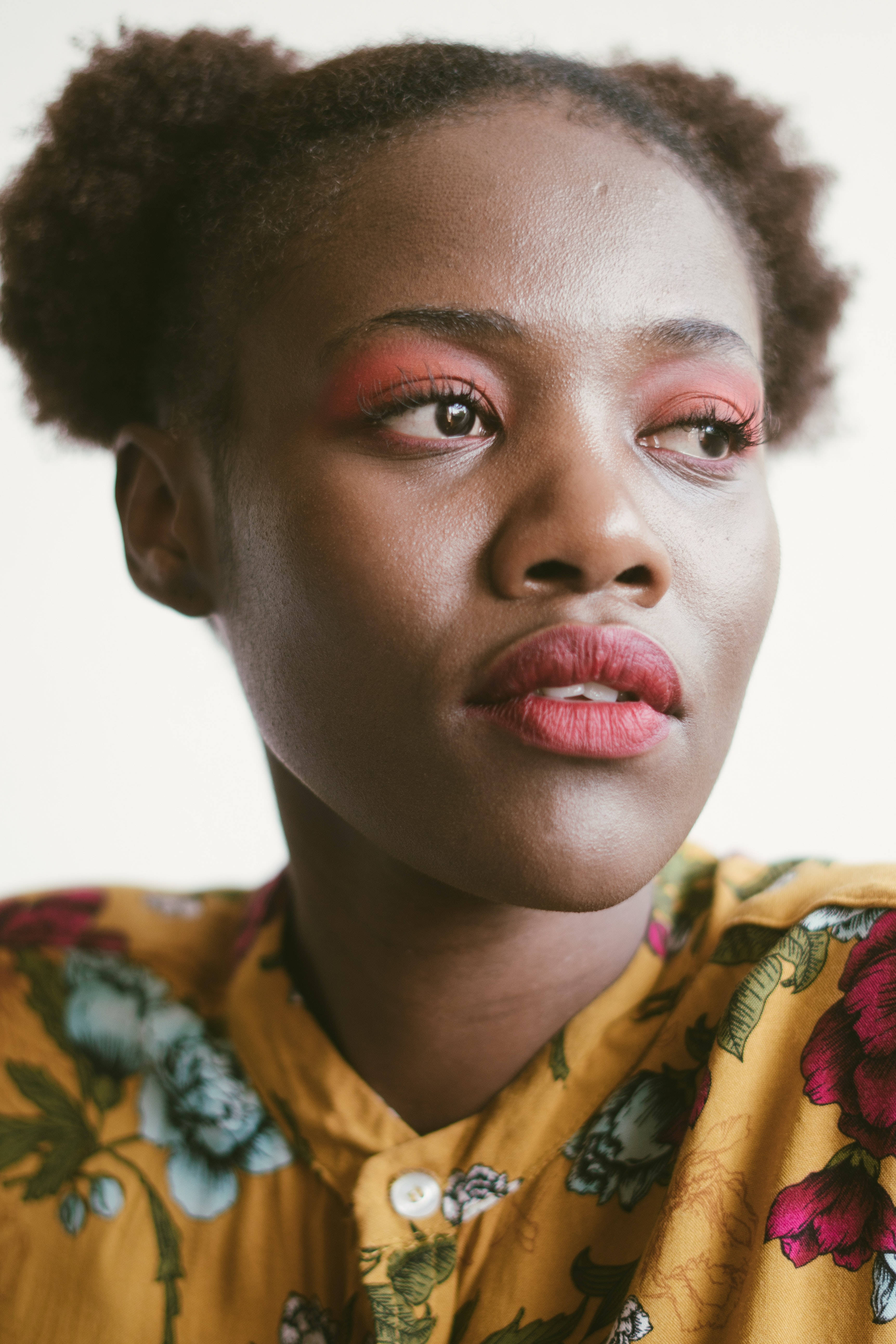 vibrant pink eyeshadow, curly hair styled in two buns, floral yellow blouse, 5K Phone Wallpaper