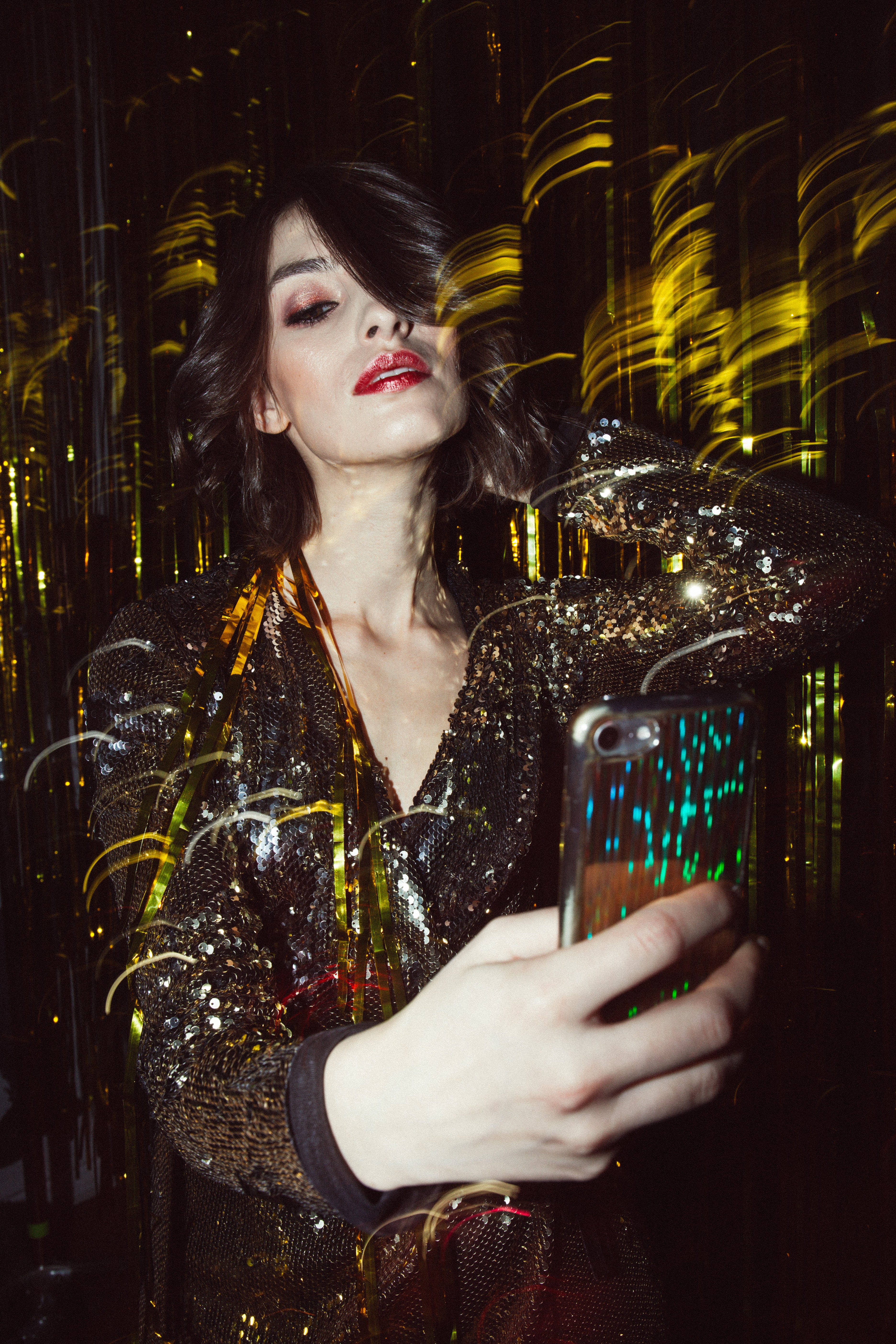 Beautiful iPhone, glittering gold jacket, swirling golden light trails, 5K Phone Wallpaper