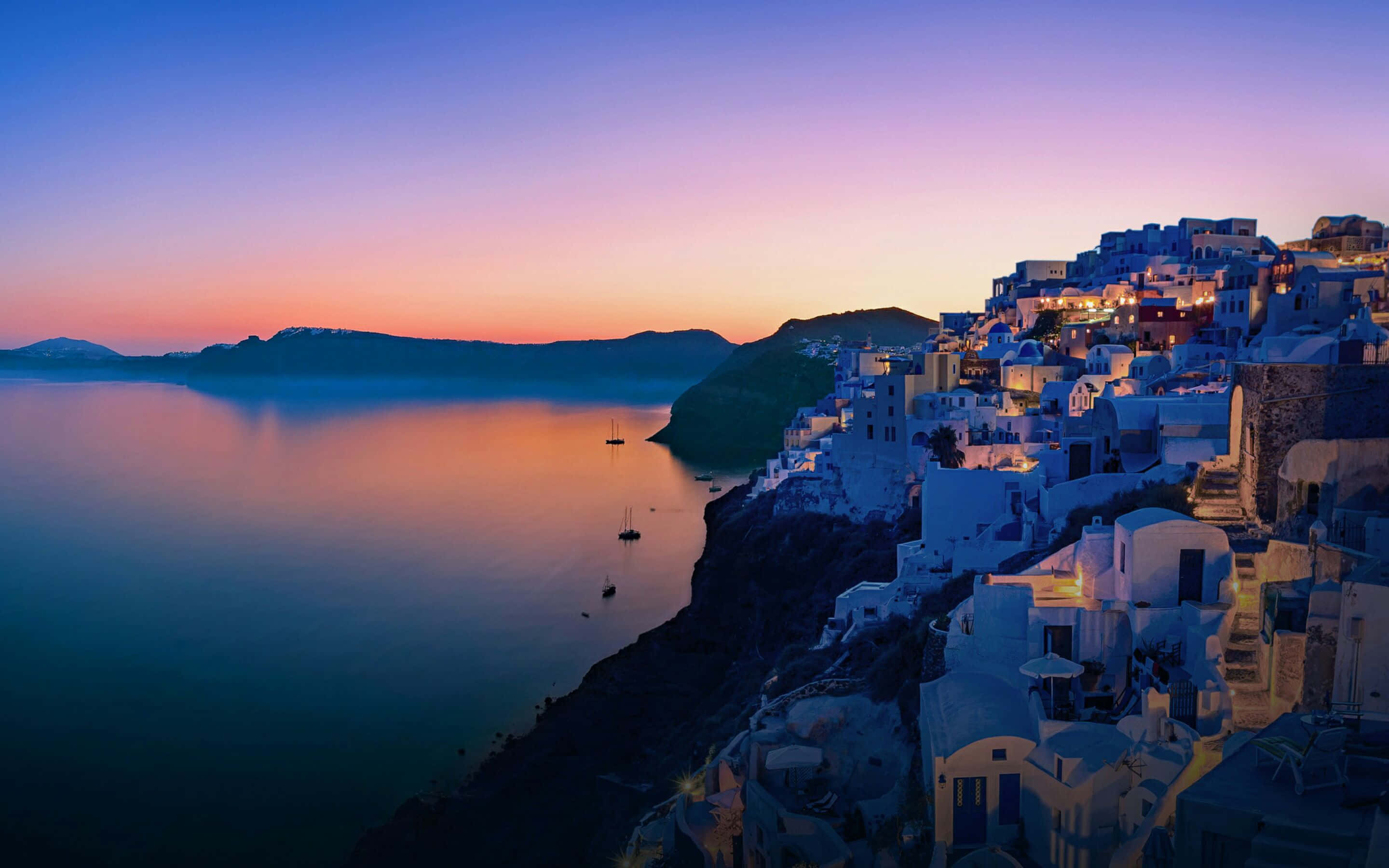 white-washed cliffside village, twilight, warm lights, 2K Desktop Wallpaper