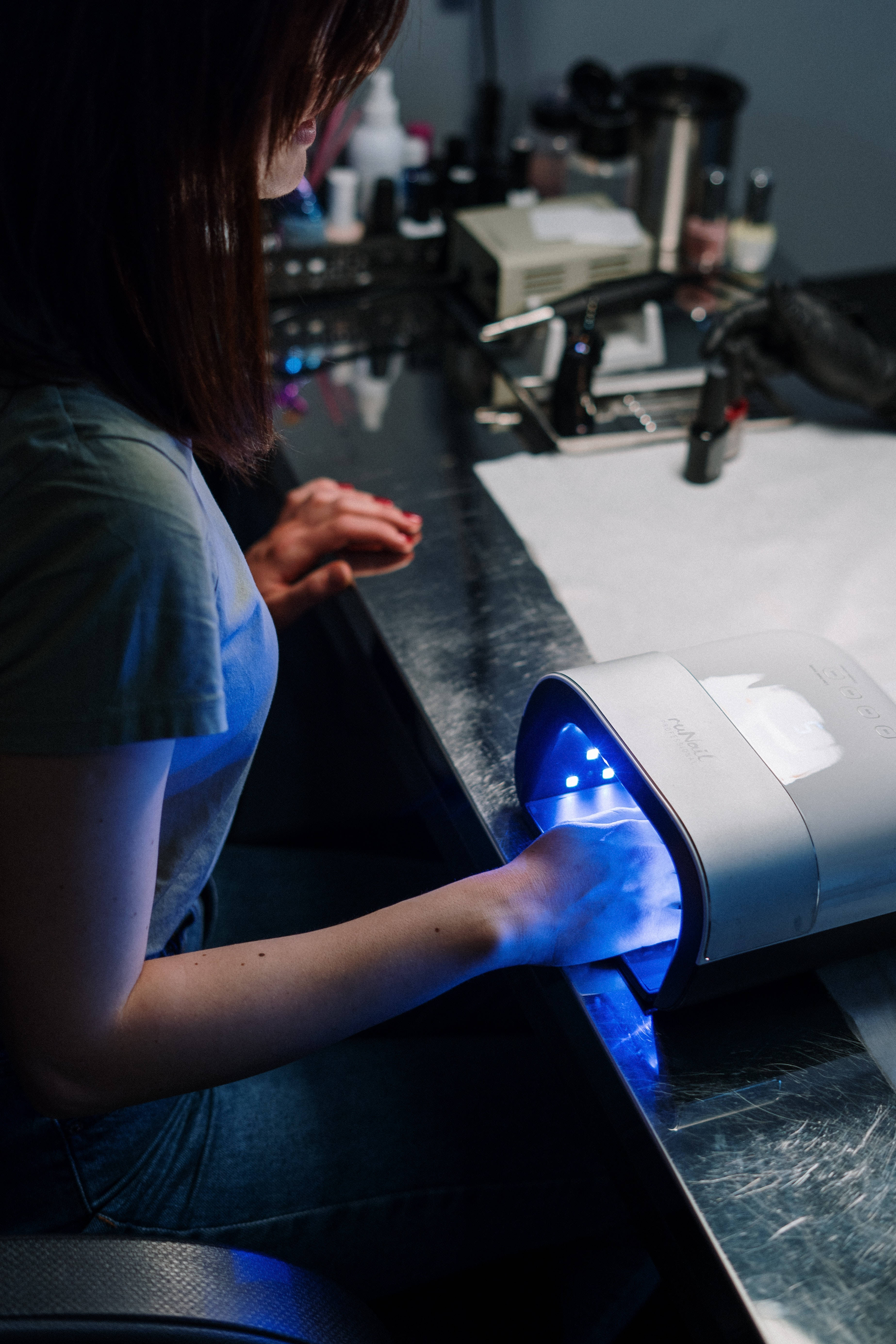 Nail Tech, beauty salon, glowing blue UV nail lamp, 5K Phone Wallpaper