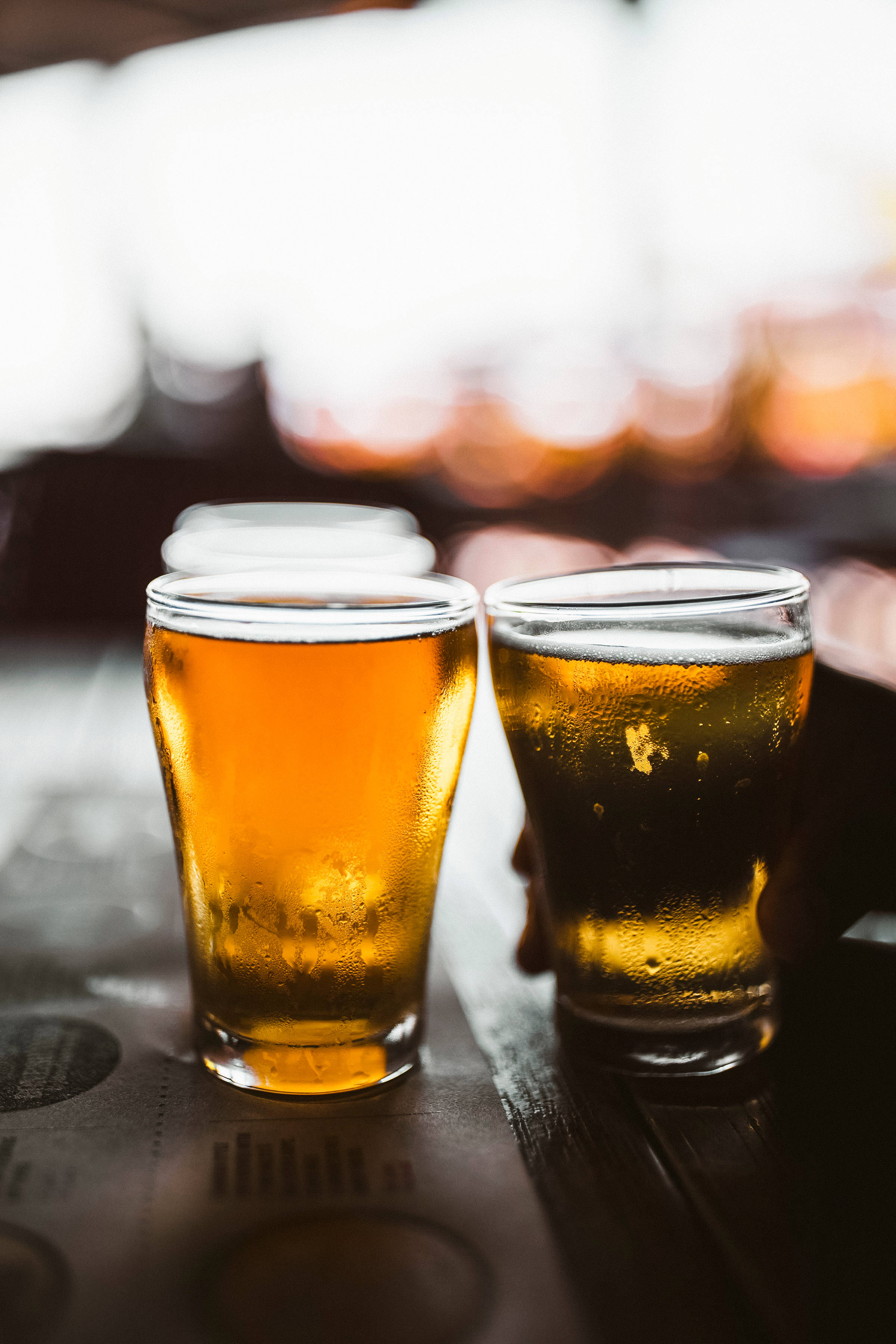 amber beer glasses, condensation, dark wooden bar, 2K Phone Wallpaper