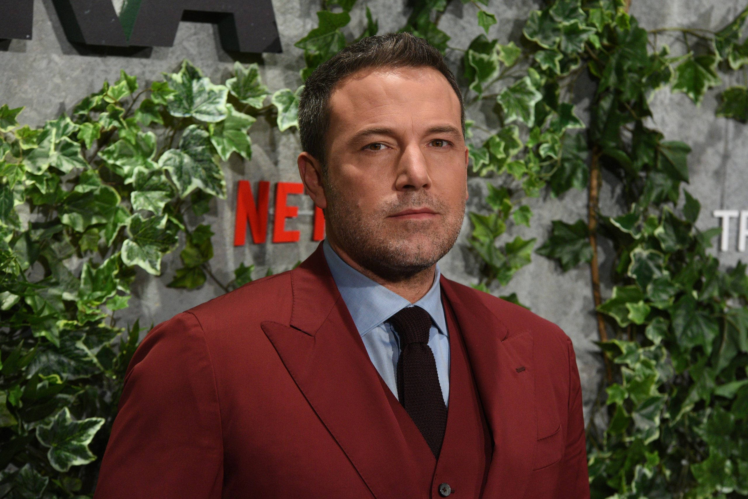 Ben Affleck, red suit, green ivy wall, 2K Desktop Wallpaper