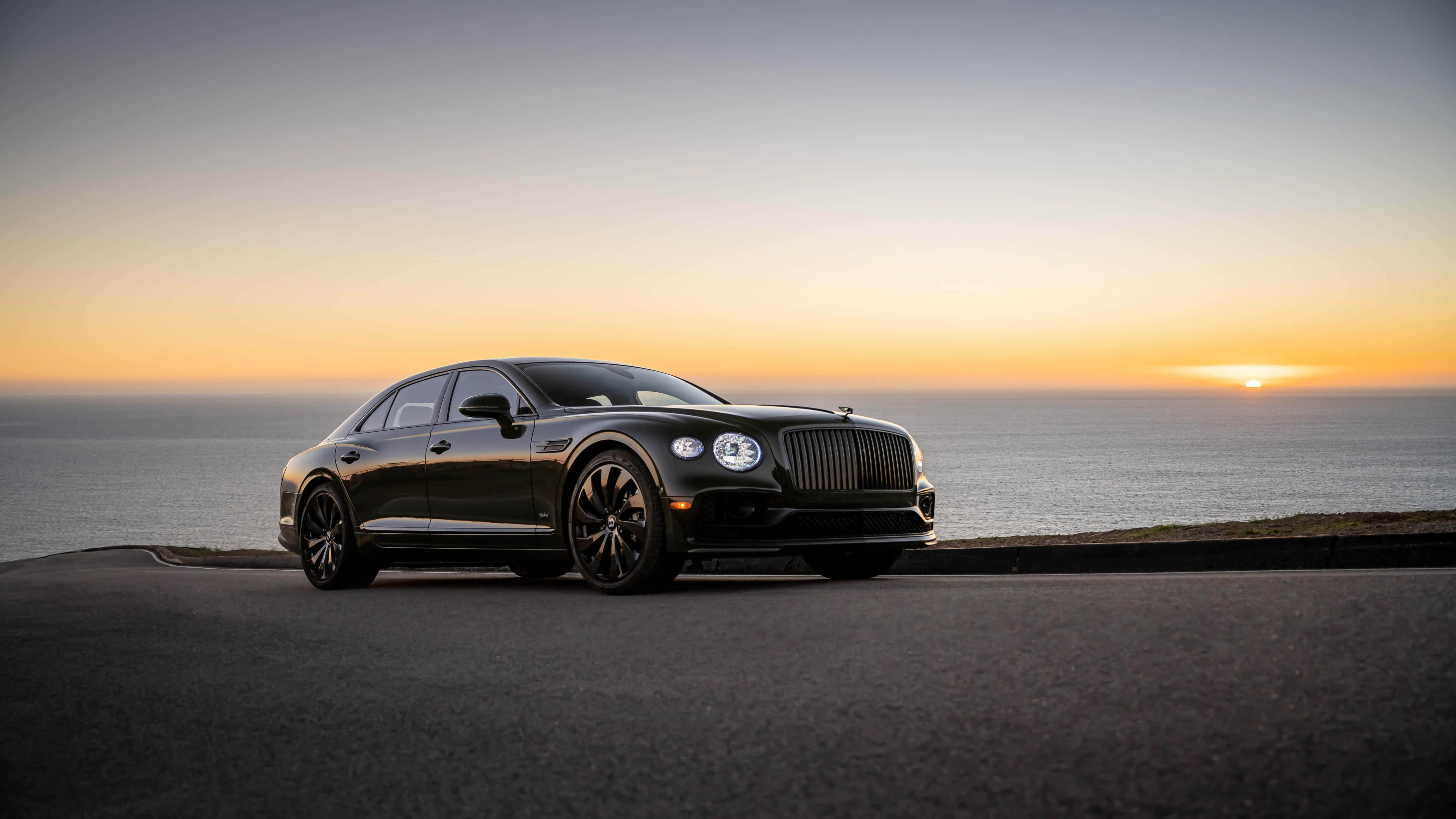 Bentley Flying Spur, sleek black, coastal road, 4K Desktop Wallpaper