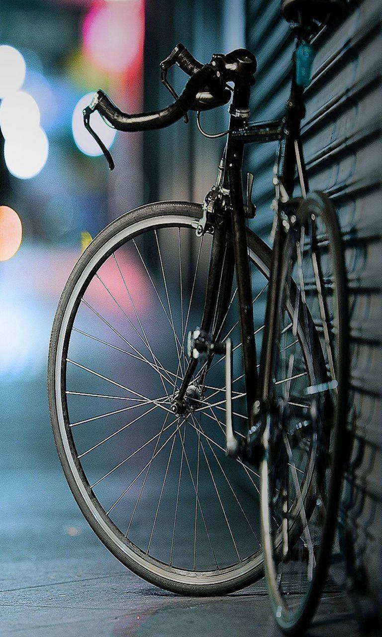 Bicycle iPhone, sleek black bicycle, brick wall, HD Phone Wallpaper