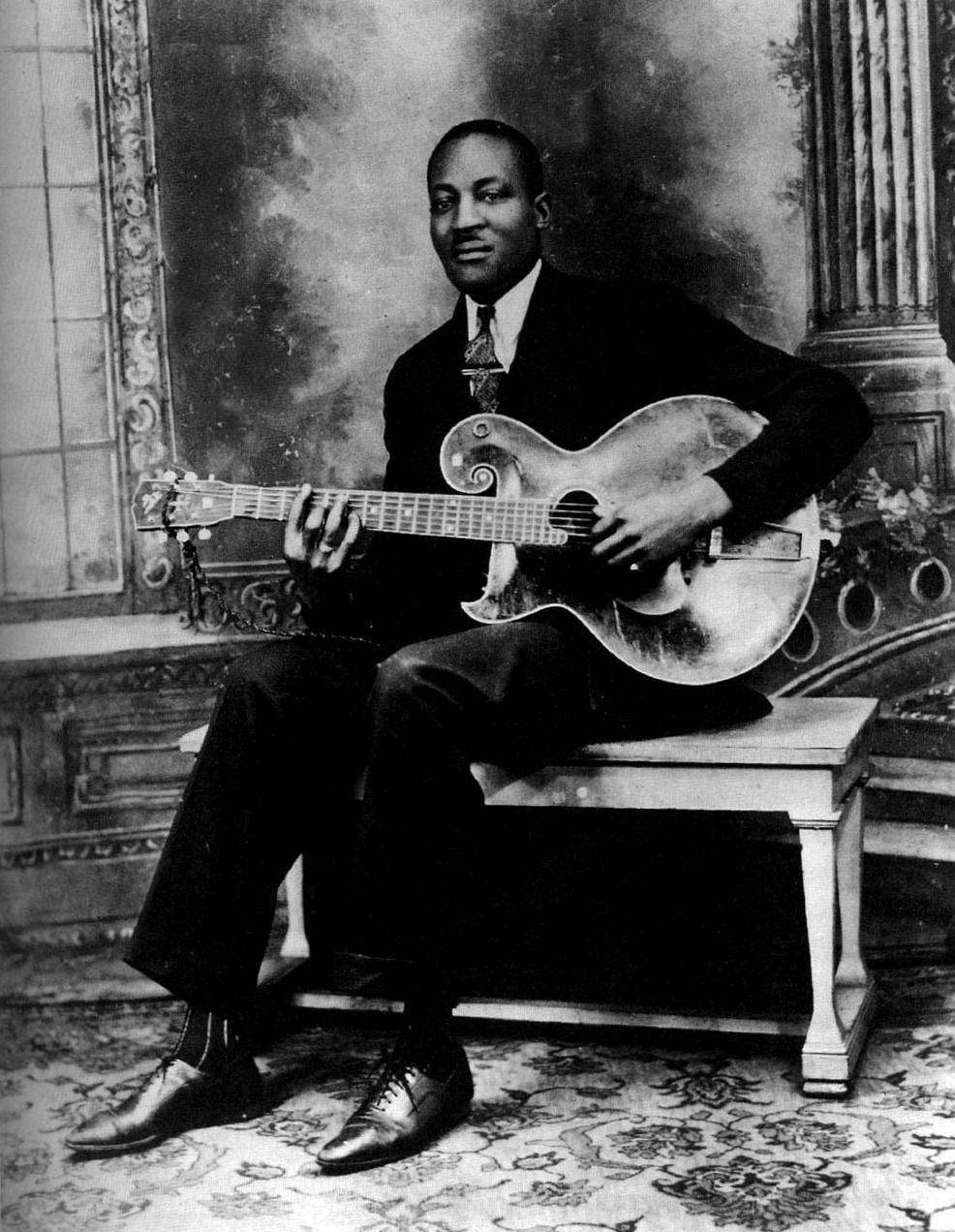 Big Bill Broonzy, vintage archtop guitar, ornate studio backdrop, SD Phone Wallpaper