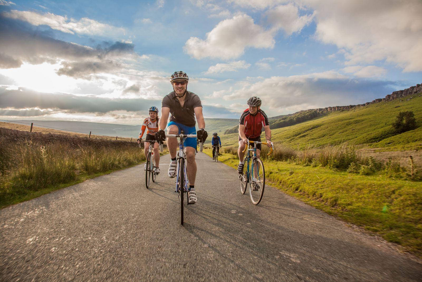 Group Bike Ride, winding rural road, dramatic cloudy sky, HD Desktop Wallpaper