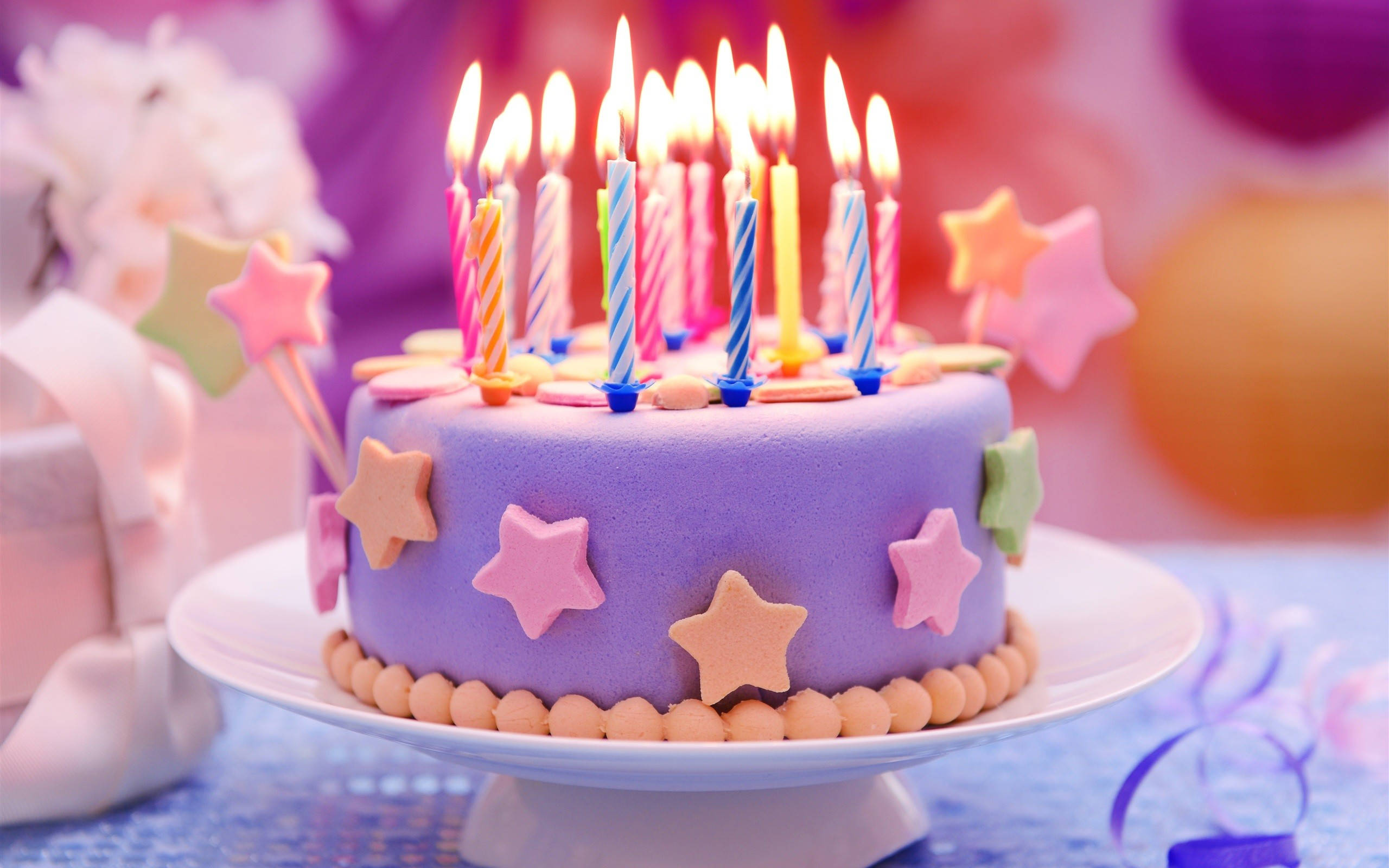 colorful stars birthday cake candles, vibrant purple birthday cake, lit candles, 2K Desktop Wallpaper
