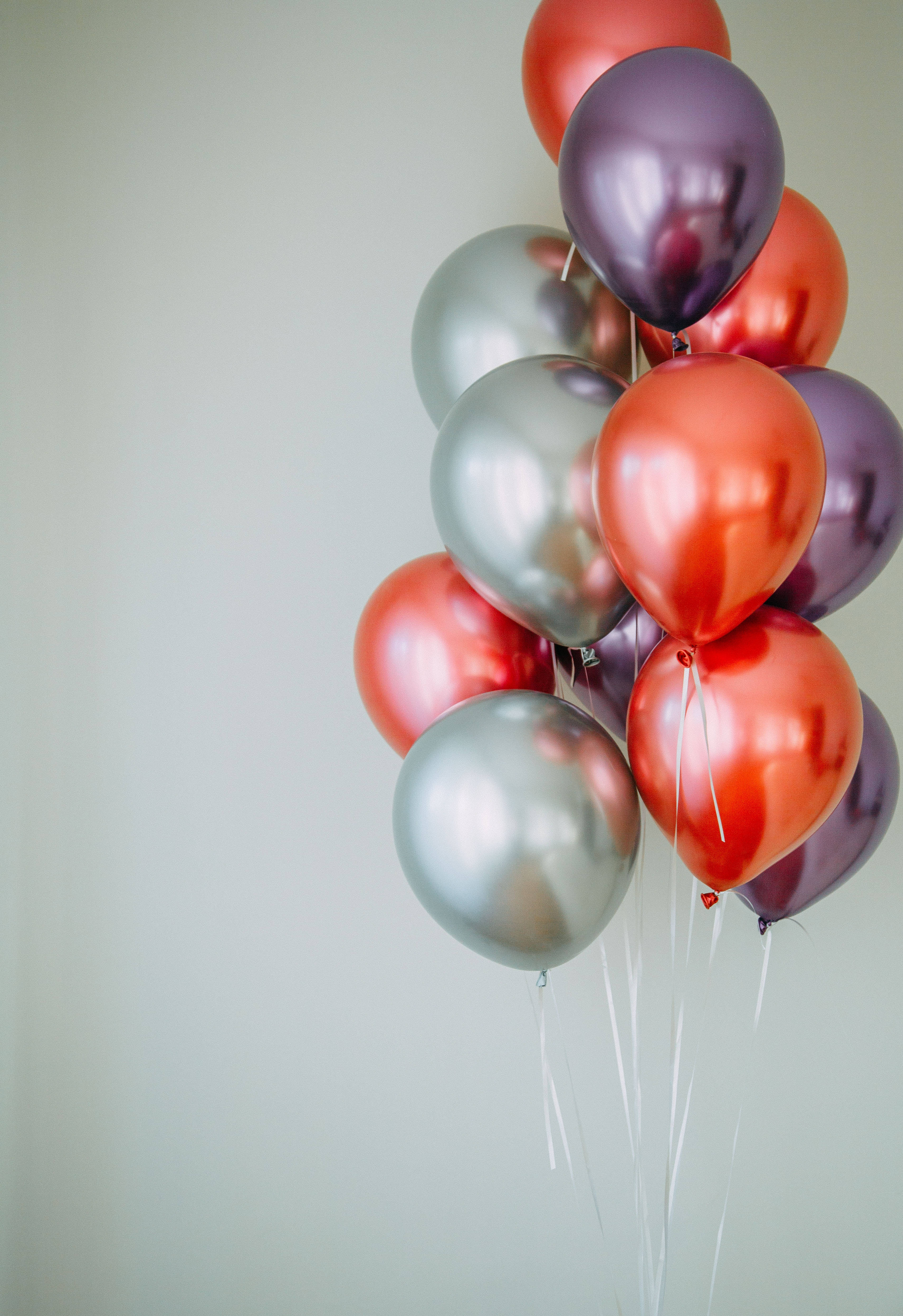 shiny metallic balloons, red silver and purple, plain light gray wall, 4K Phone Wallpaper