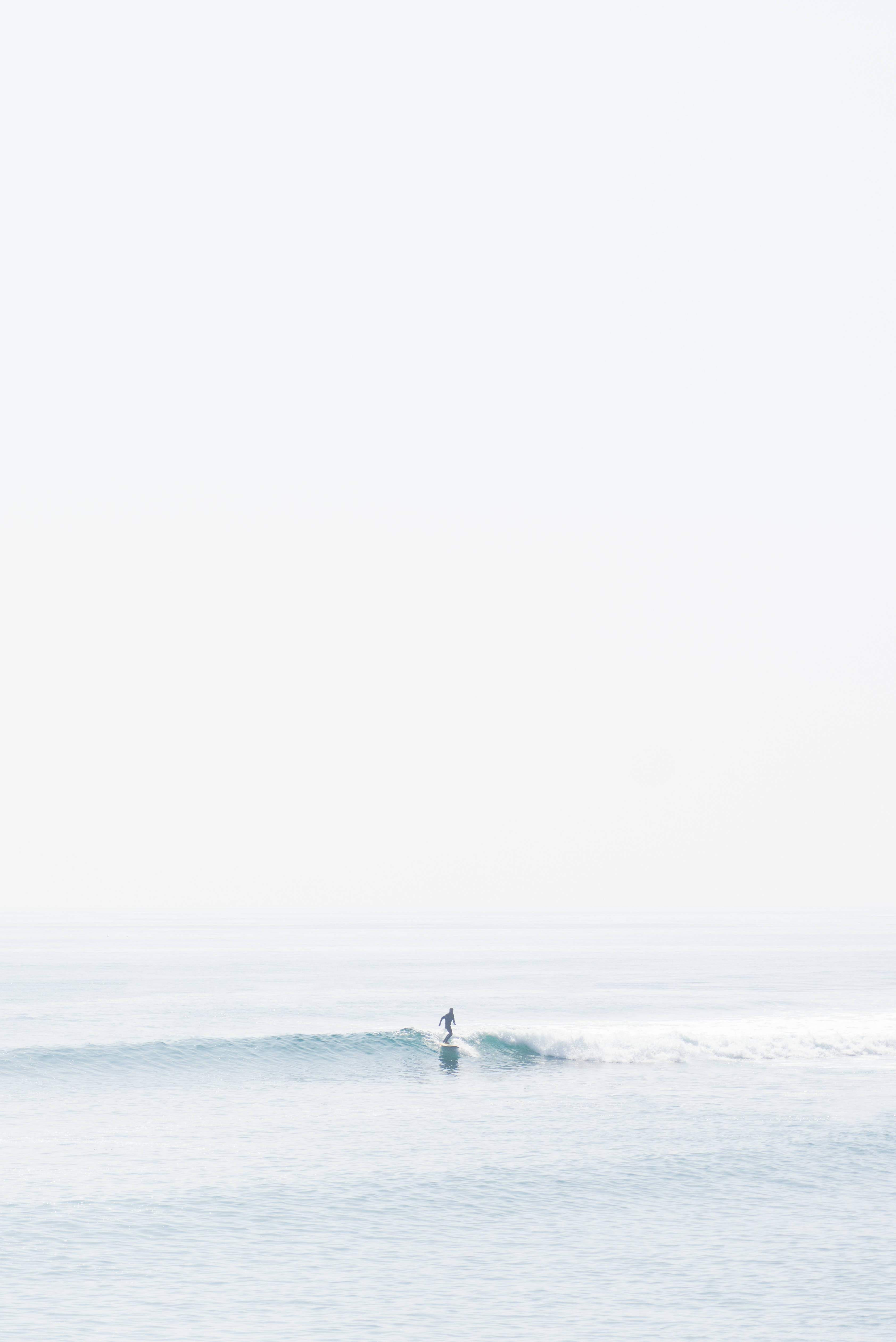 plain white themed beach, lone surfer, small wave, 4K Phone Wallpaper