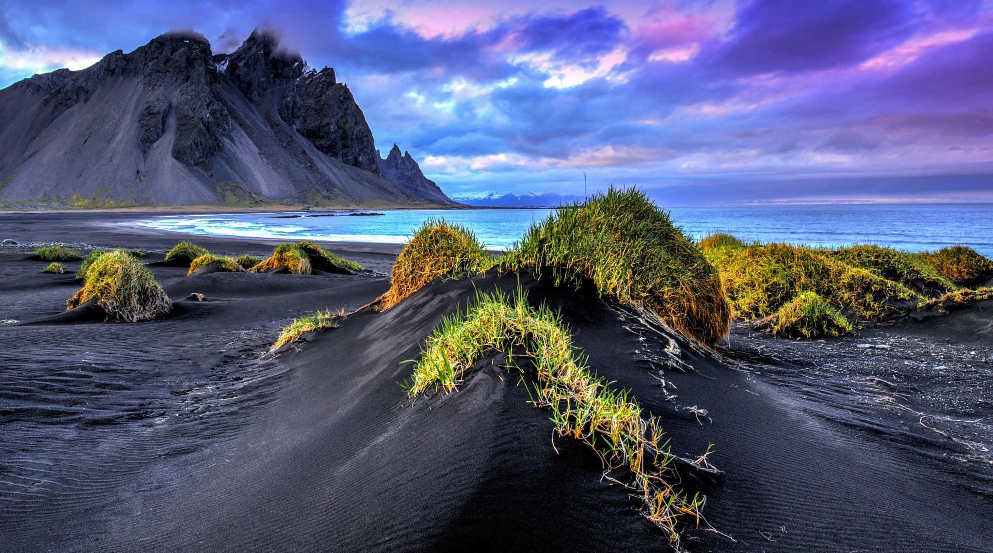 black sand beach, vibrant purple sunset, green tufts of grass, Full HD Desktop Wallpaper