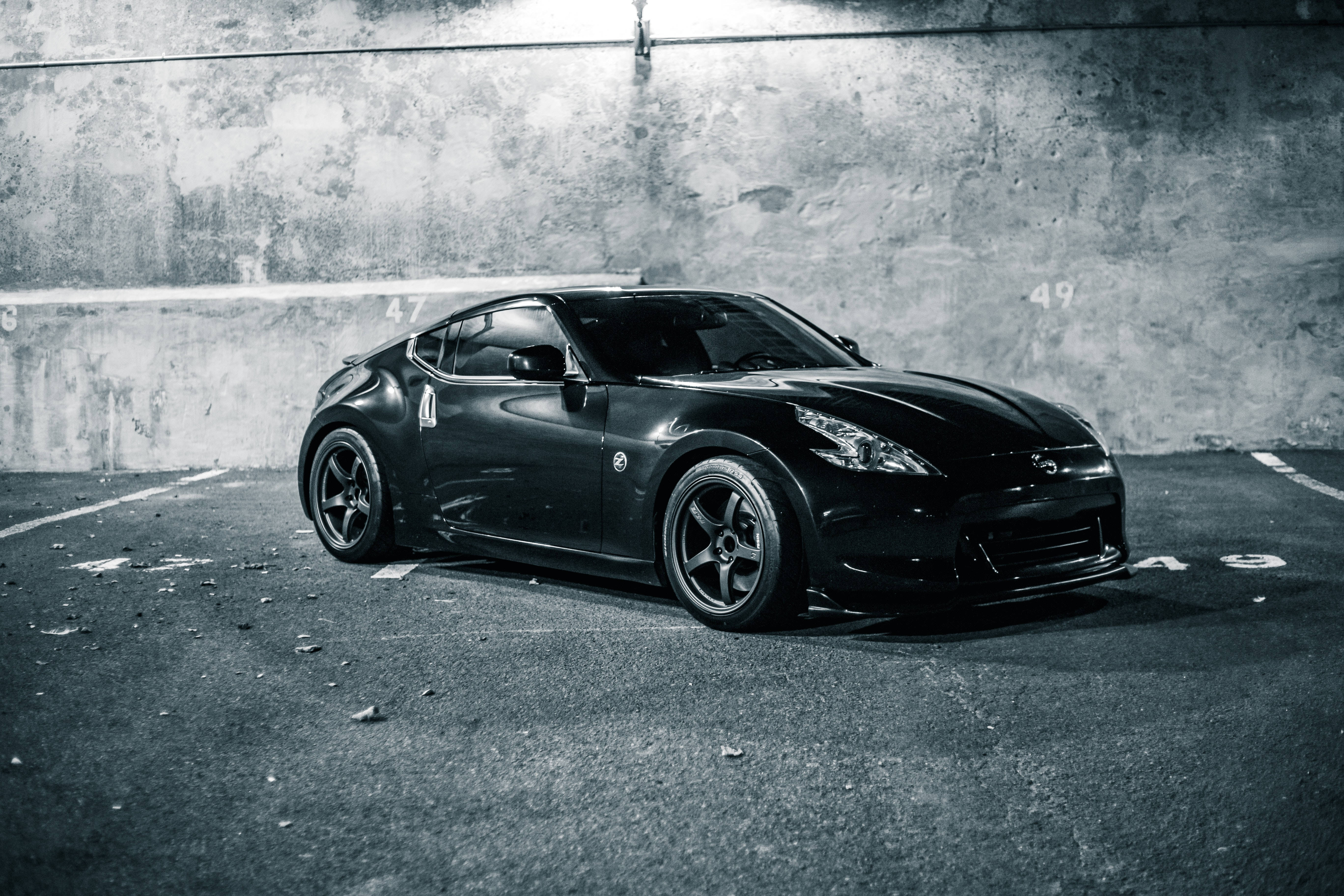 black sports car, gritty concrete garage, stark lighting, 5K Desktop Wallpaper