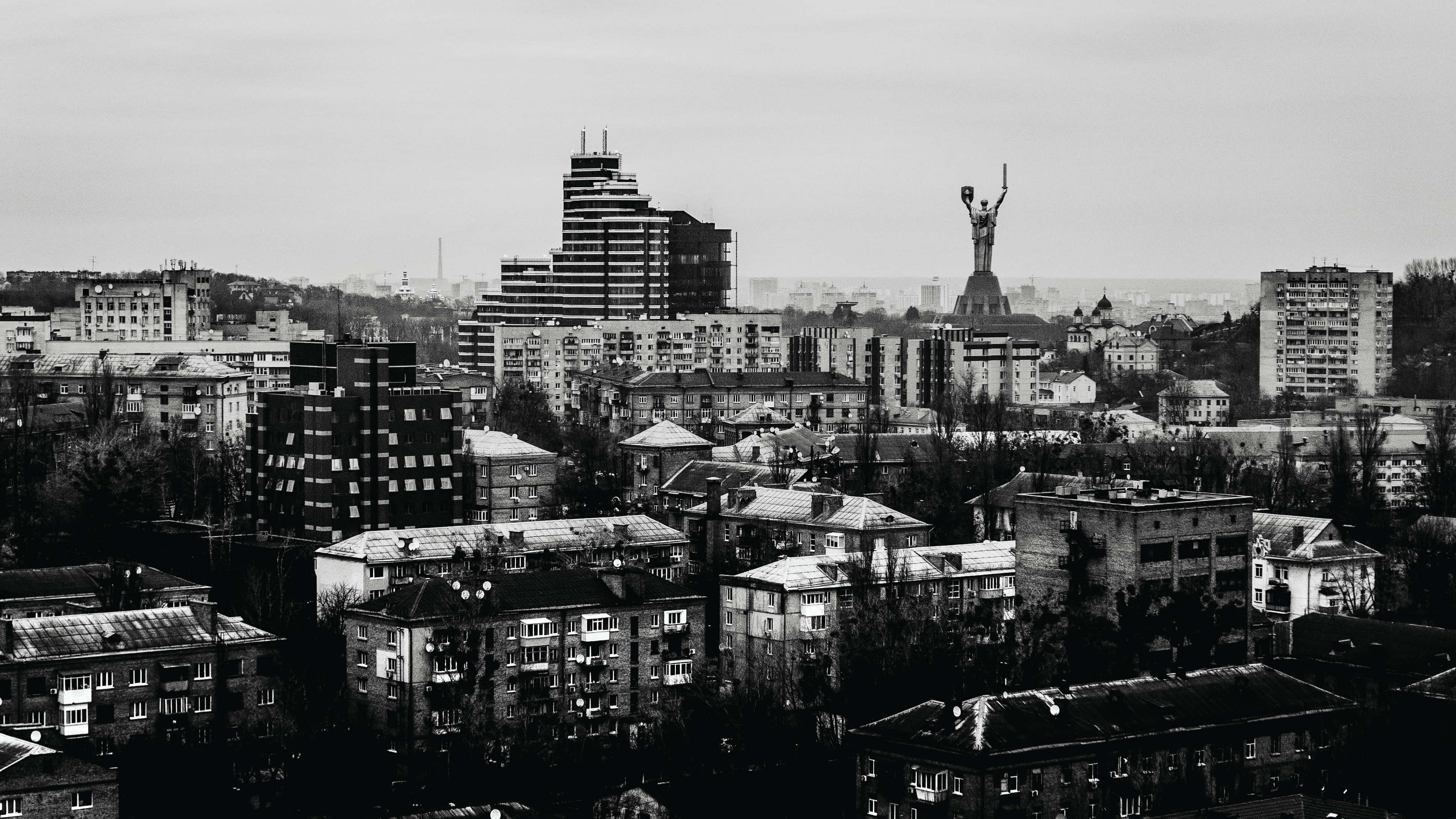 black and white city, monochrome cityscape, towering statue of a raised-arm figure, 4K Desktop Wallpaper