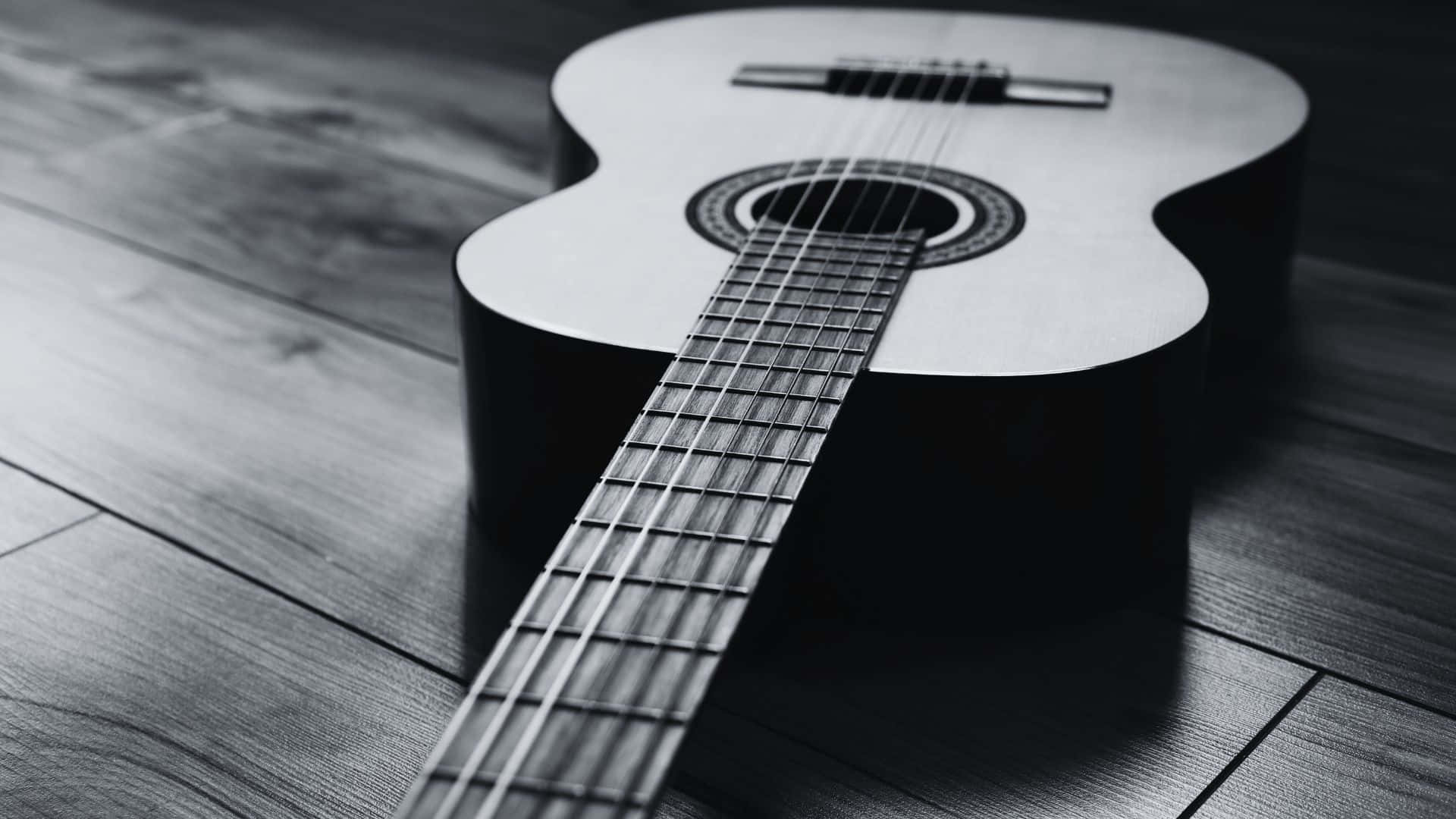 black and white acoustic guitar, wooden floor, dramatic shadows, Full HD Desktop Wallpaper