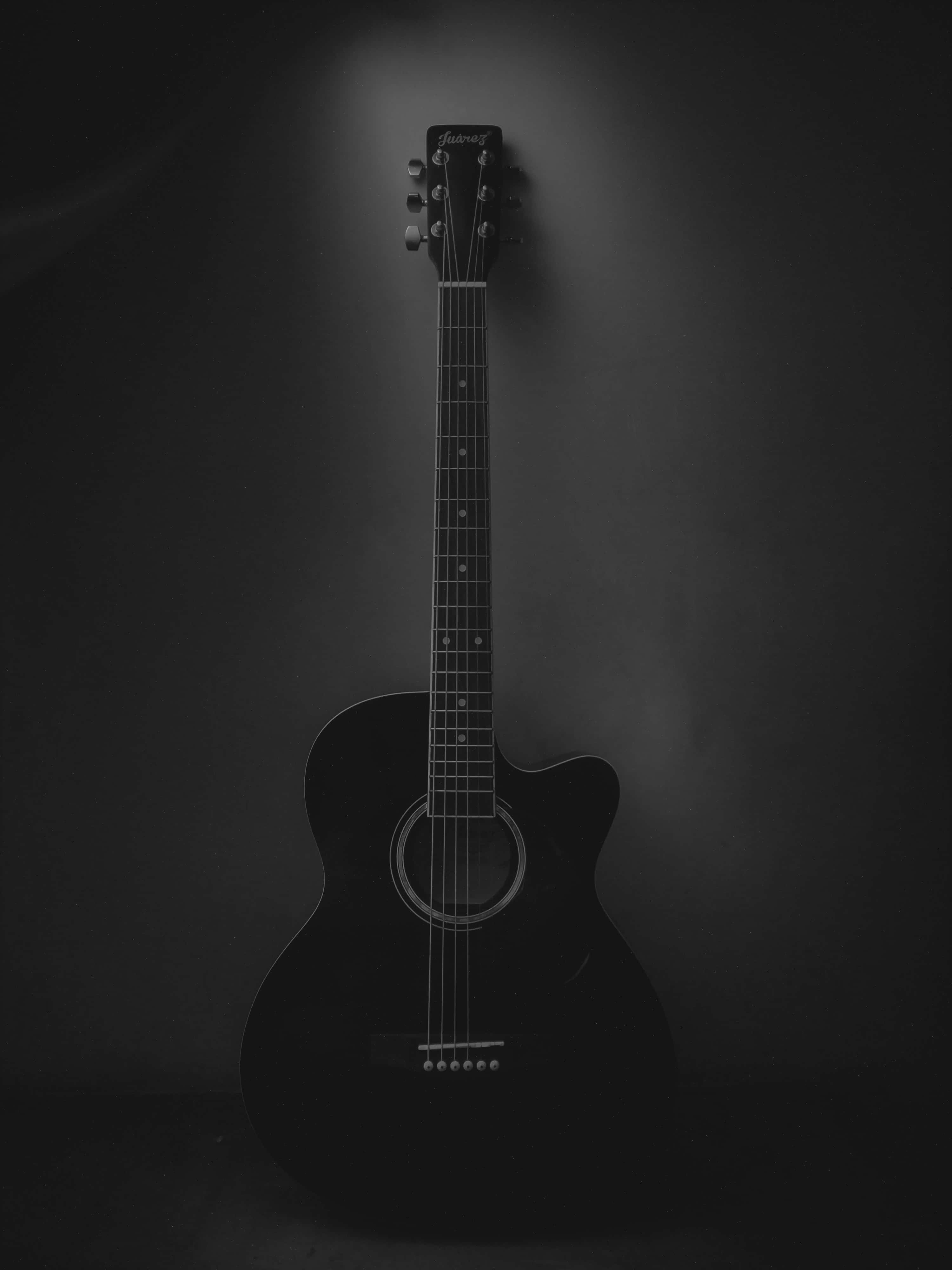 black acoustic guitar, dark backdrop, single spotlight, 4K Phone Wallpaper