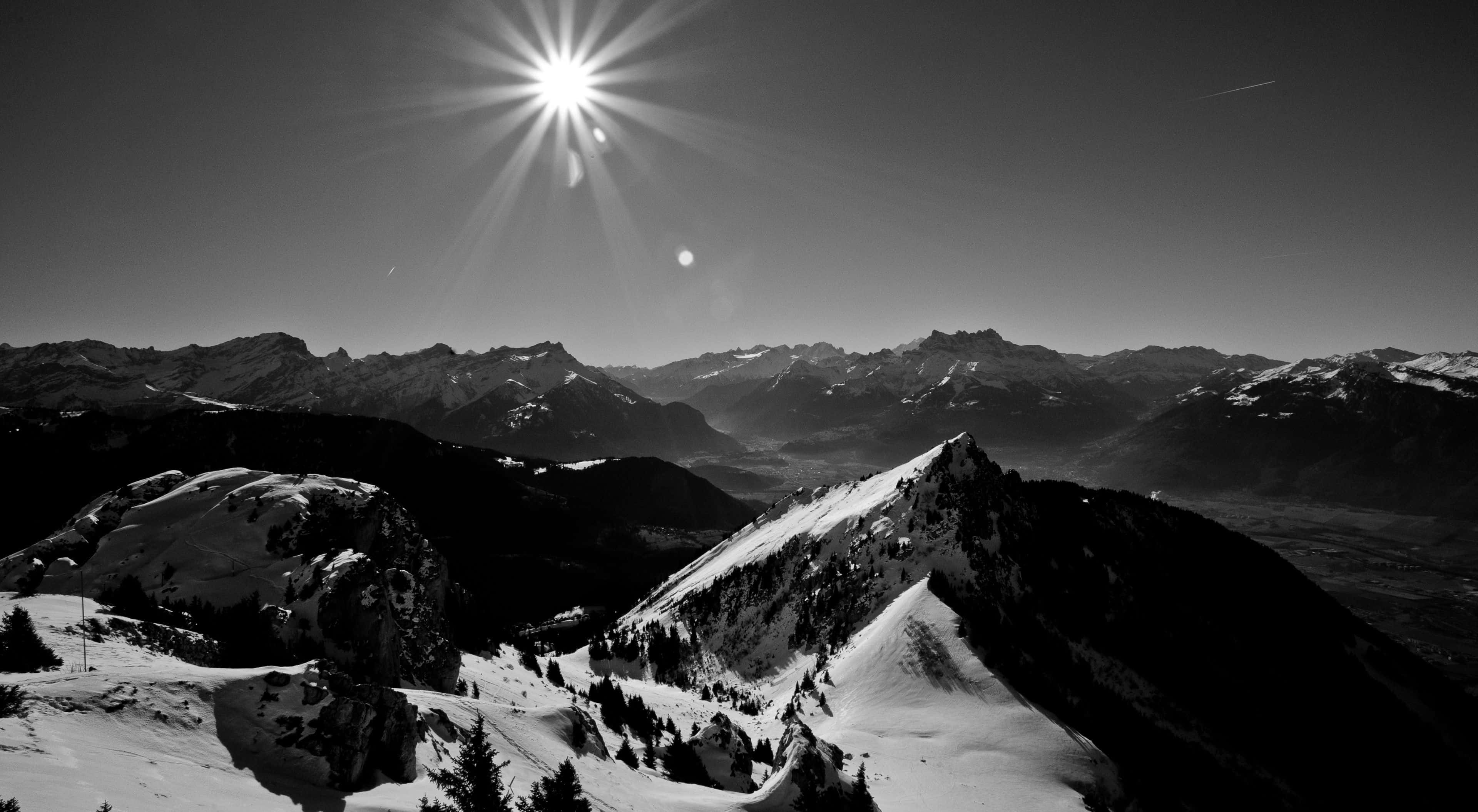 black and white mountain landscape, radiant sun, snow-capped peaks, 4K Desktop Wallpaper