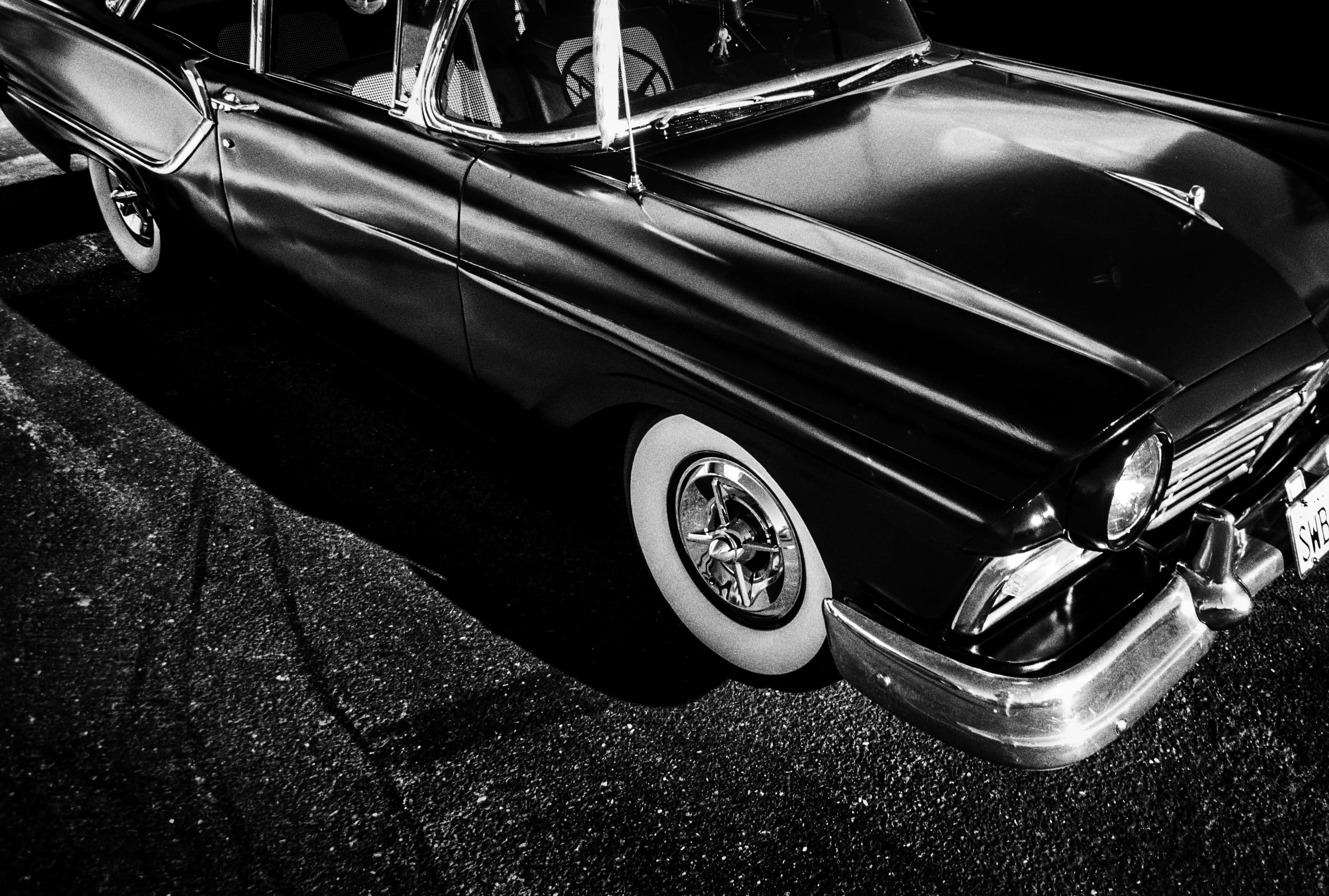 black classic car, dramatic lighting, sharp shadows, 2K Desktop Wallpaper