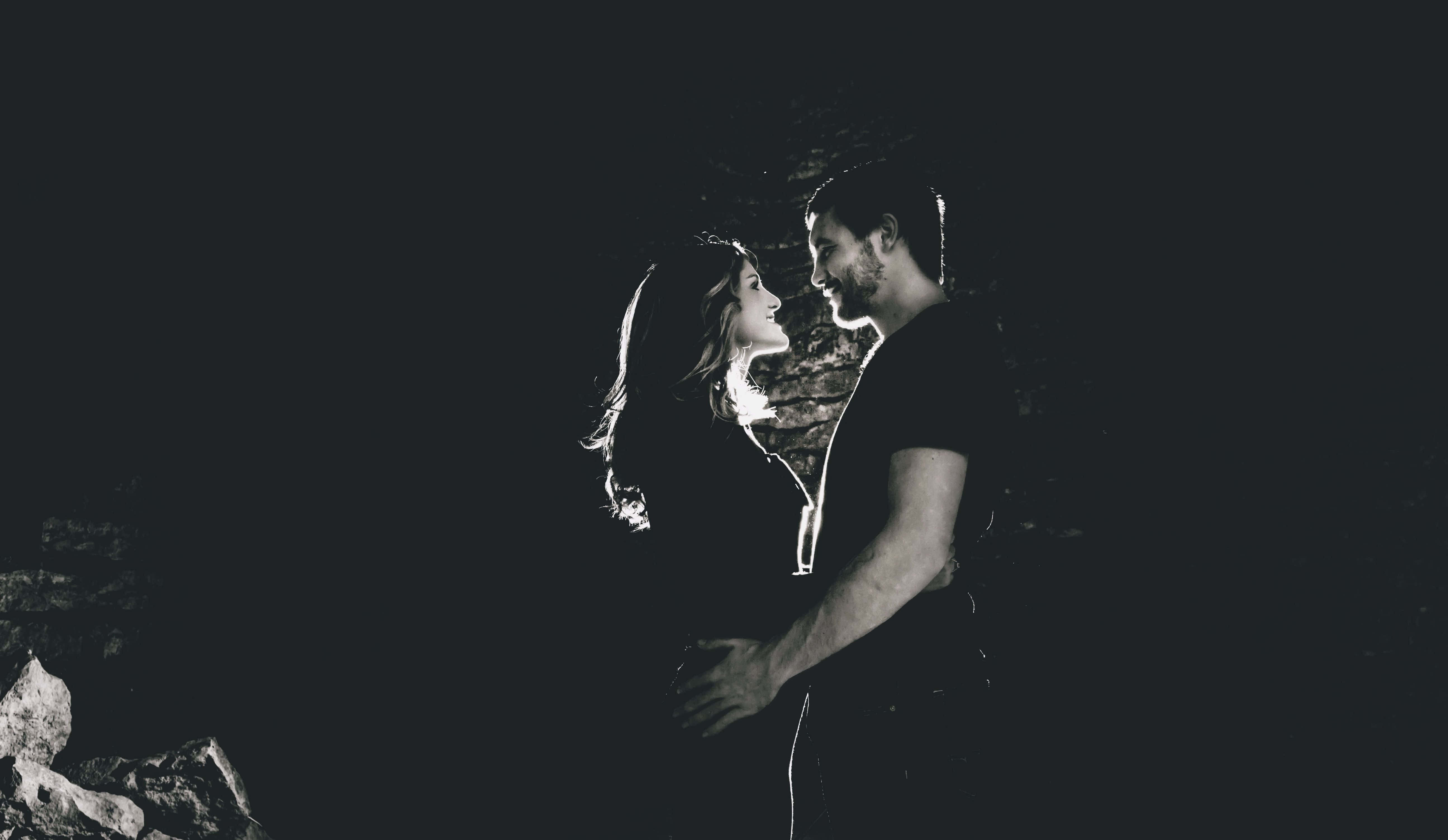 black couple, dimly lit cave, dramatic backlighting, 5K Desktop Wallpaper