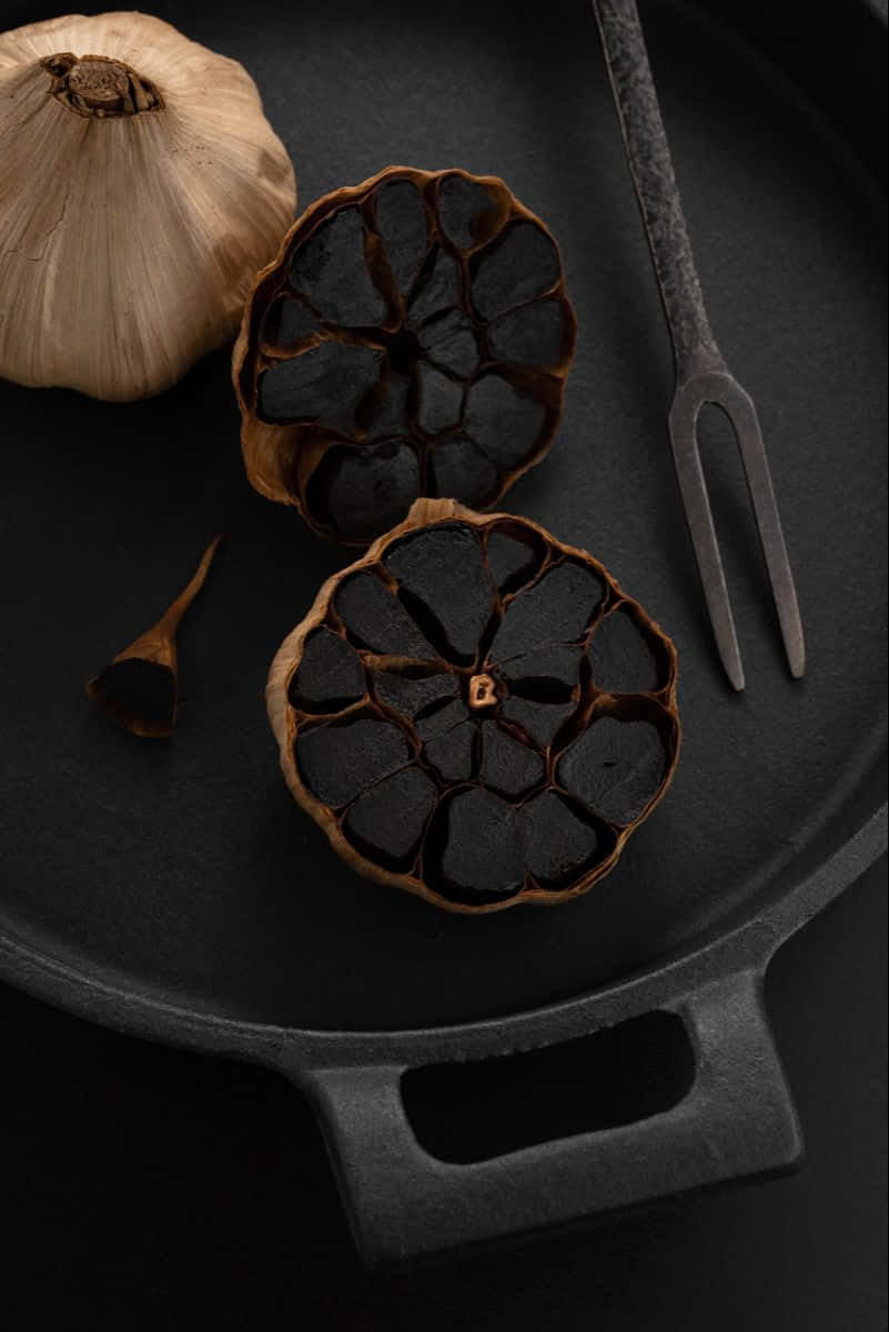 black garlic, rustic black cast iron skillet, roasted black garlic cloves, SD Phone Wallpaper