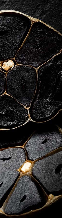 black garlic, glossy dark skins, golden-brown inner membranes, SD Phone Wallpaper