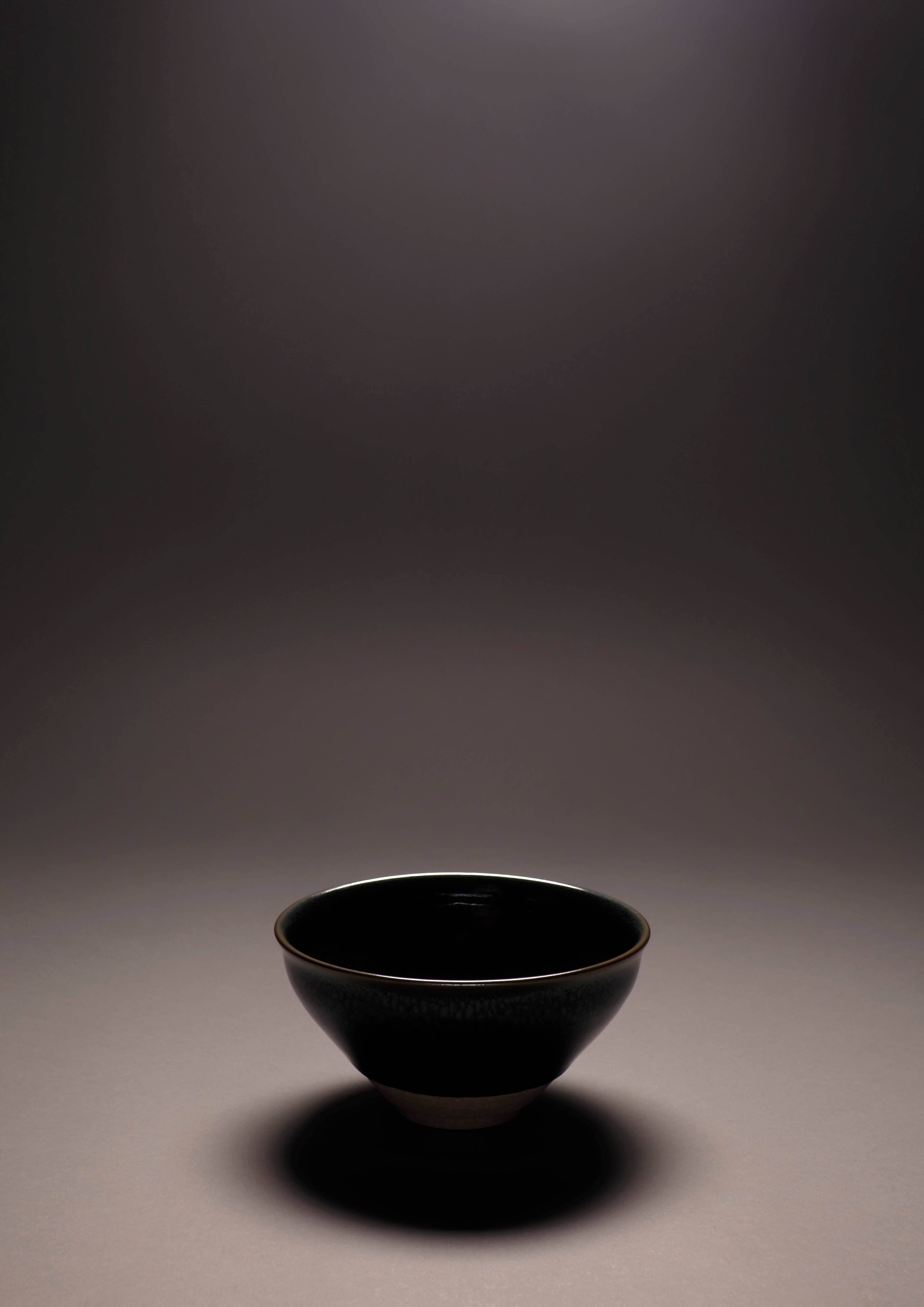 glossy black ceramic bowl, subtle texture, dramatic spotlight, 5K Phone Wallpaper