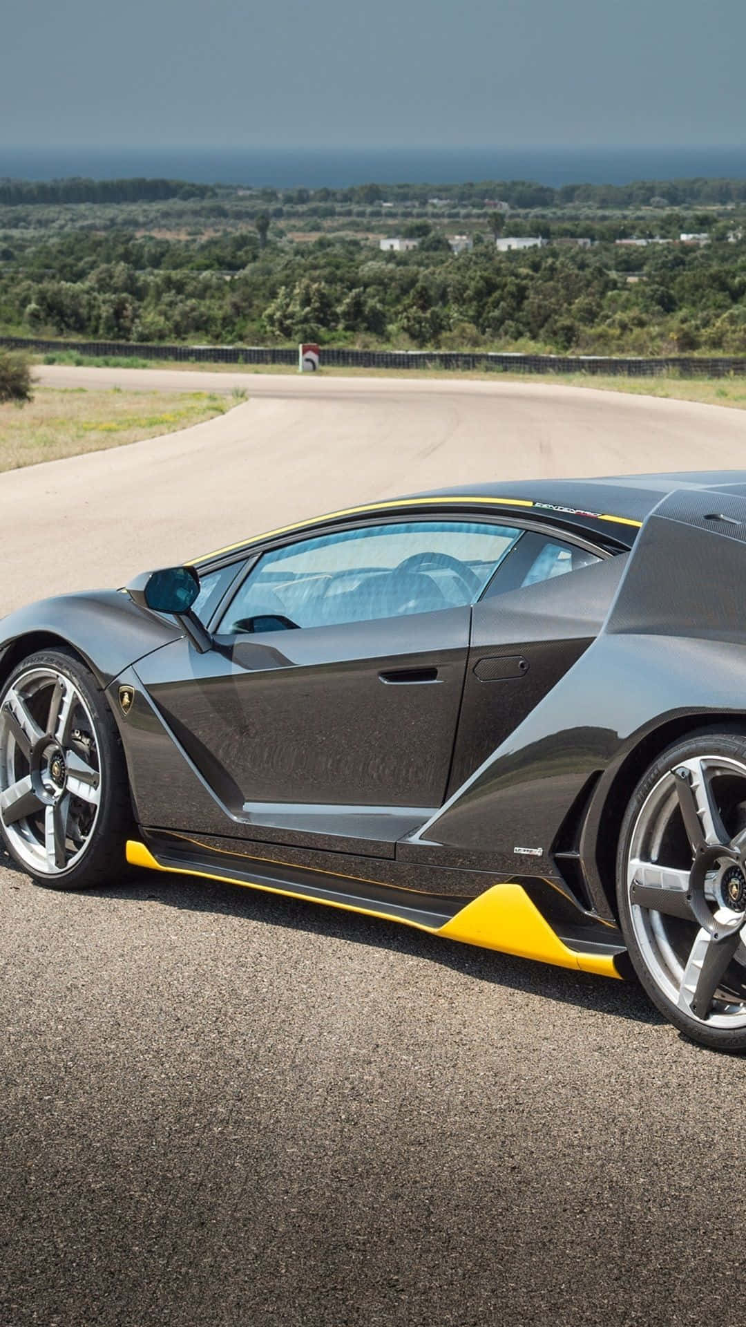 Black Lamborghini, yellow accents, winding coastal road, Full HD Phone Wallpaper