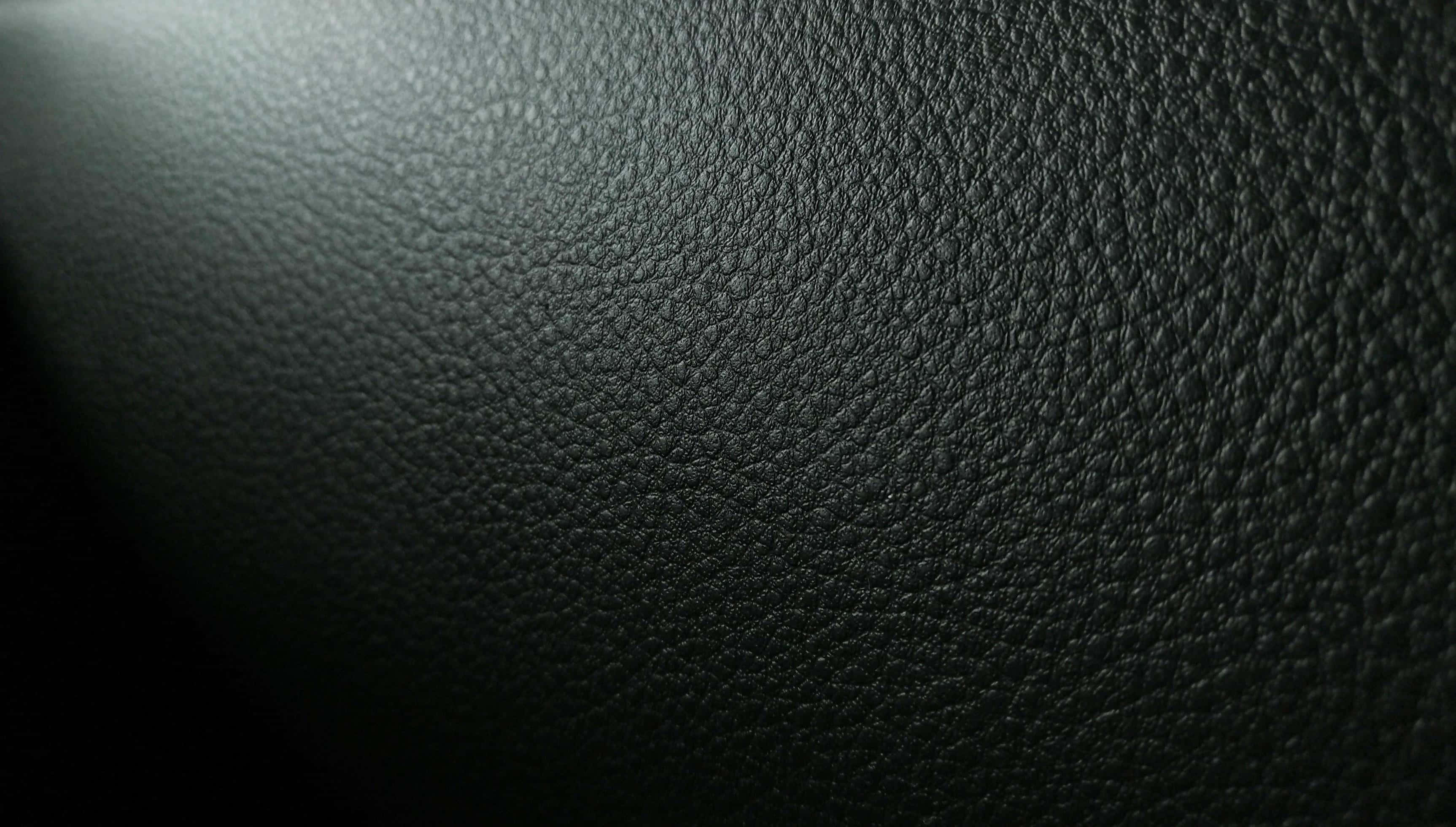 black leather, dark textured leather surface, soft gradient lighting, 2K Desktop Wallpaper