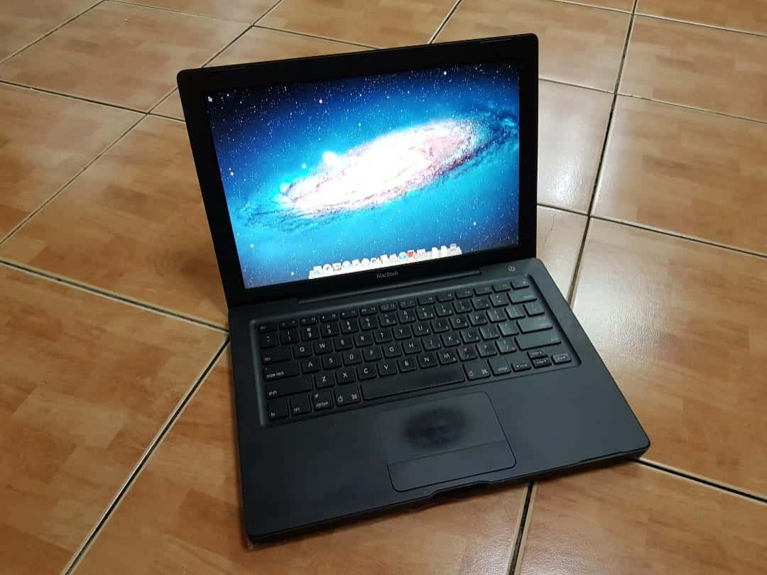 Black Macbook, wooden tiled floor, vibrant spiral galaxy wallpaper, SD Desktop Wallpaper