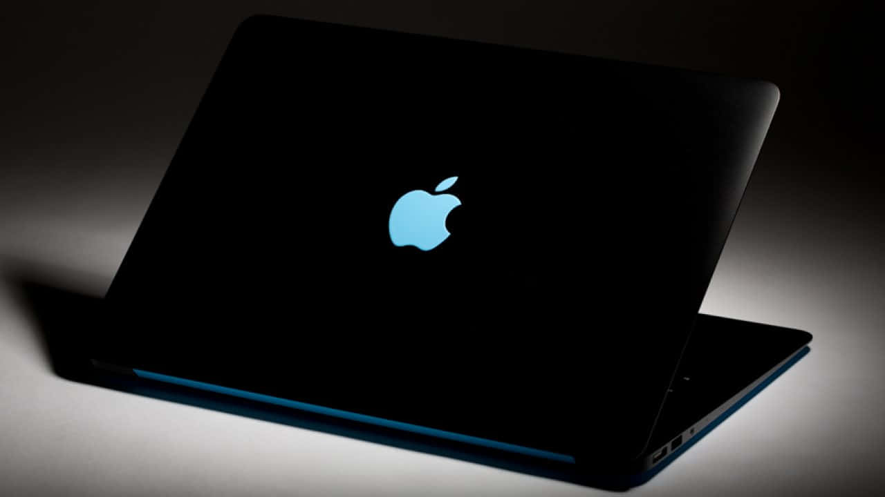 black laptop, glowing blue Apple logo, dark surface, HD Desktop Wallpaper