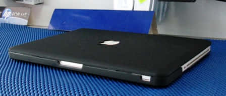 black MacBook, textured blue mat, minimalist workspace, SD Desktop Wallpaper