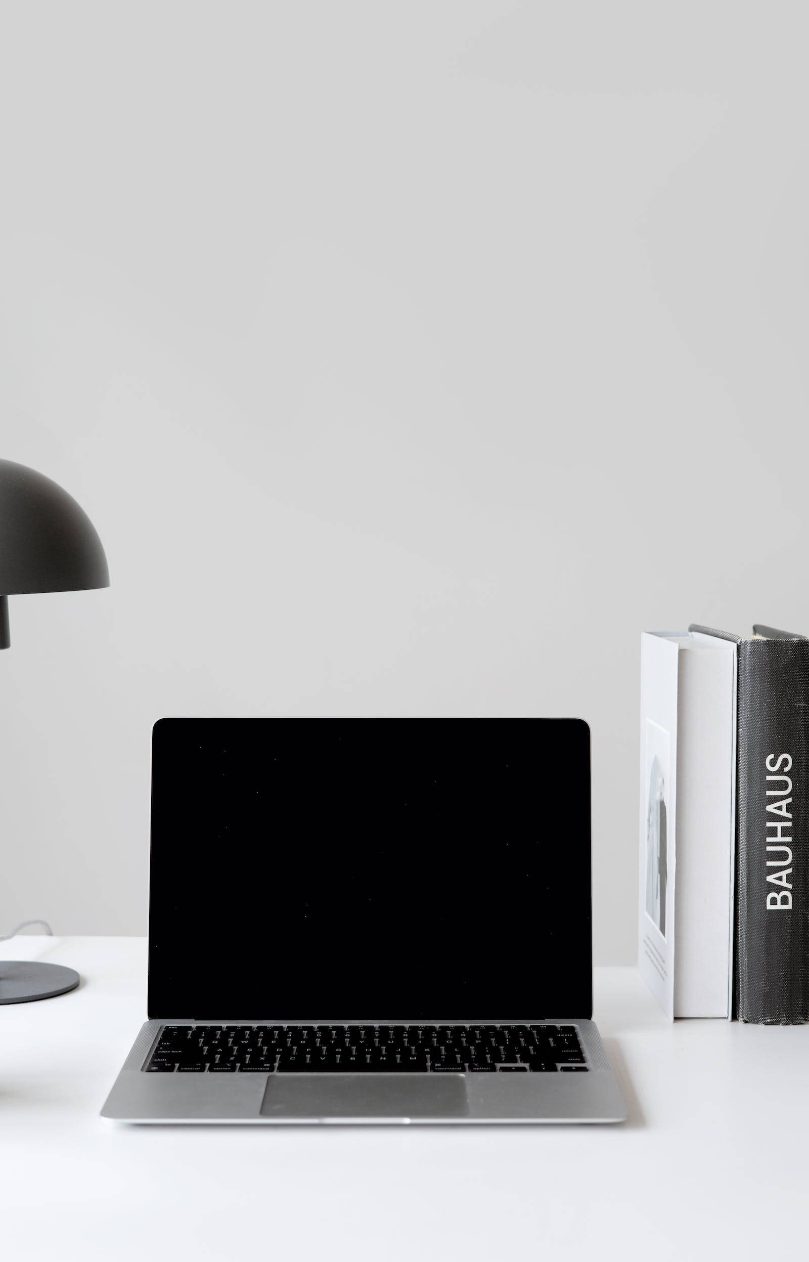 4K Black MacBook, Bauhaus books, minimalist white desk, Full HD Phone Wallpaper