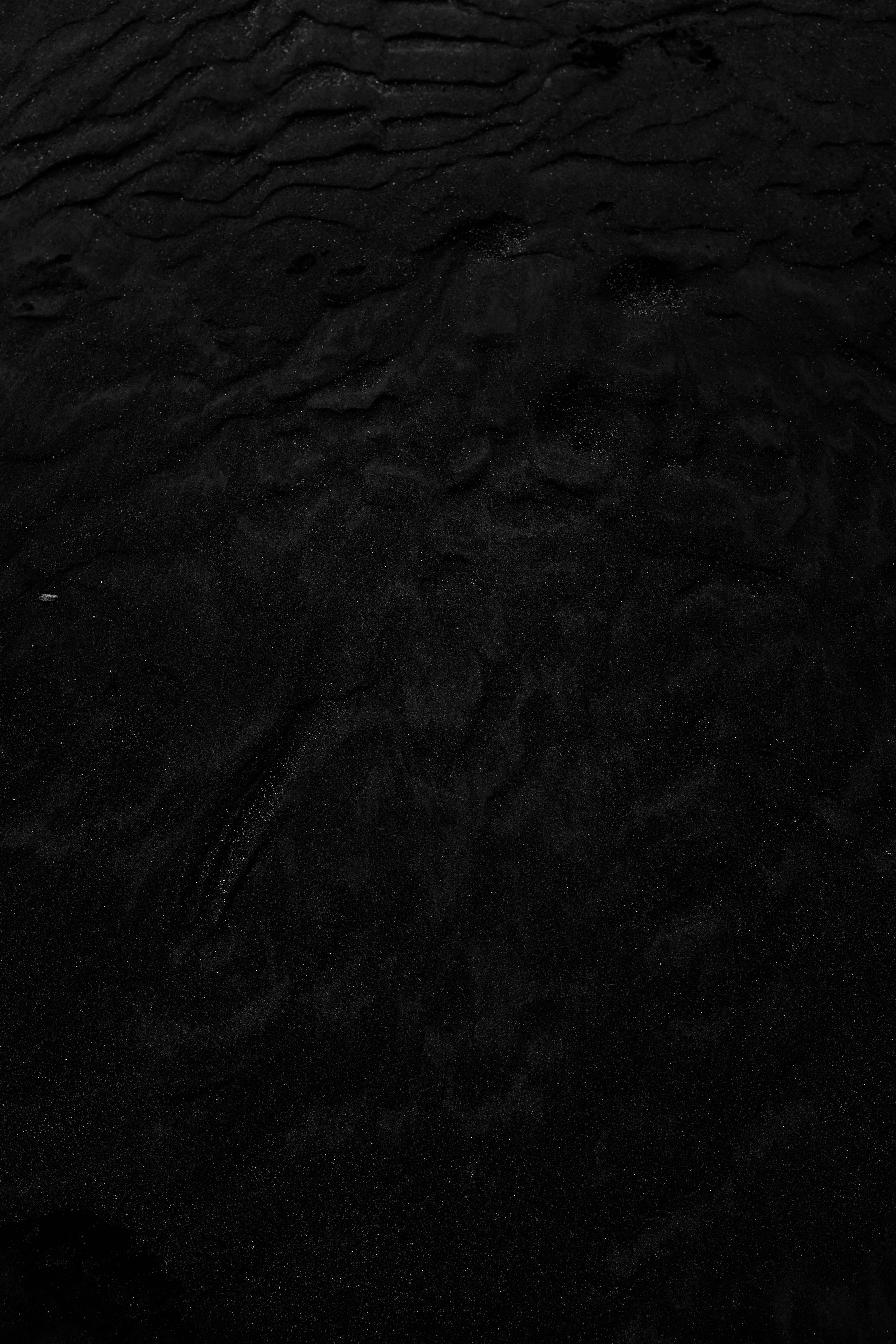 black backdrop, dark textured sand, subtle ripples, 5K Phone Wallpaper