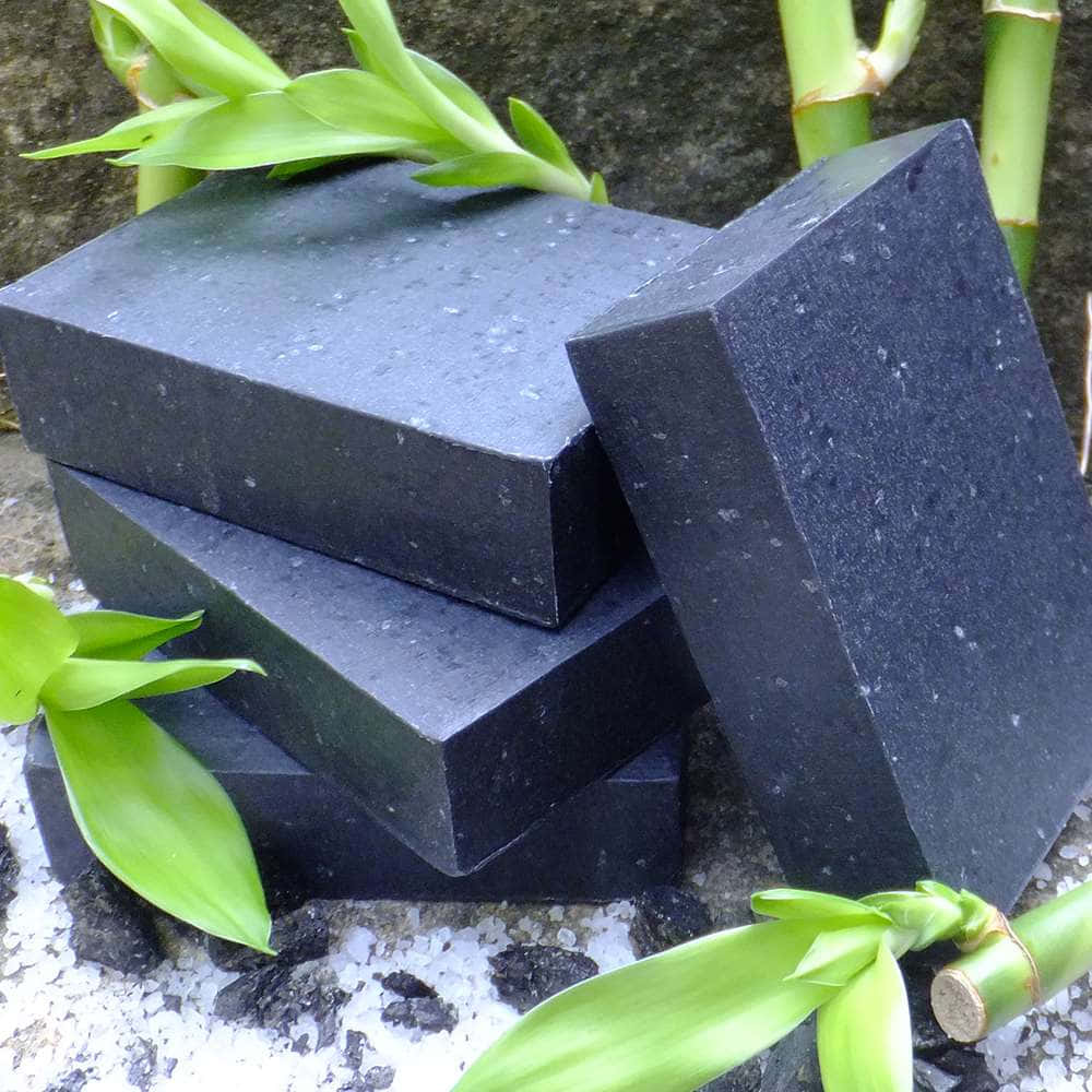 Black Soap, matte black speckled soap bars, vibrant green bamboo leaves, SD Desktop Wallpaper