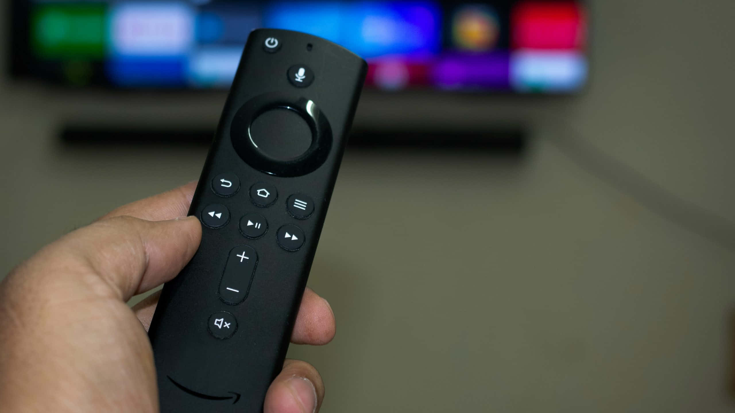 black TV remote control, glowing screen, hand, 2K Desktop Wallpaper