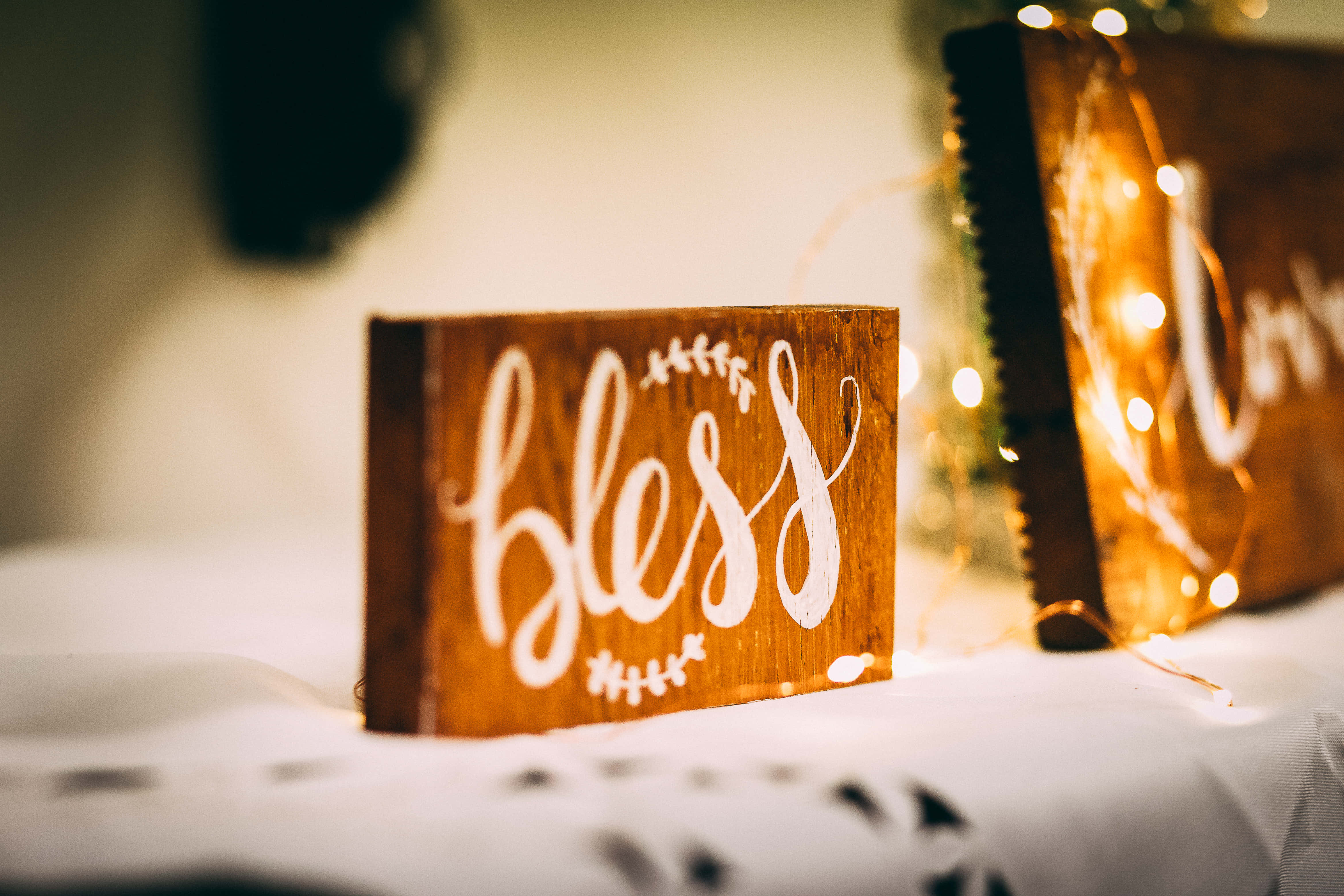 blessed wooden board, white cursive script, warm glowing fairy lights, 4K Desktop Wallpaper