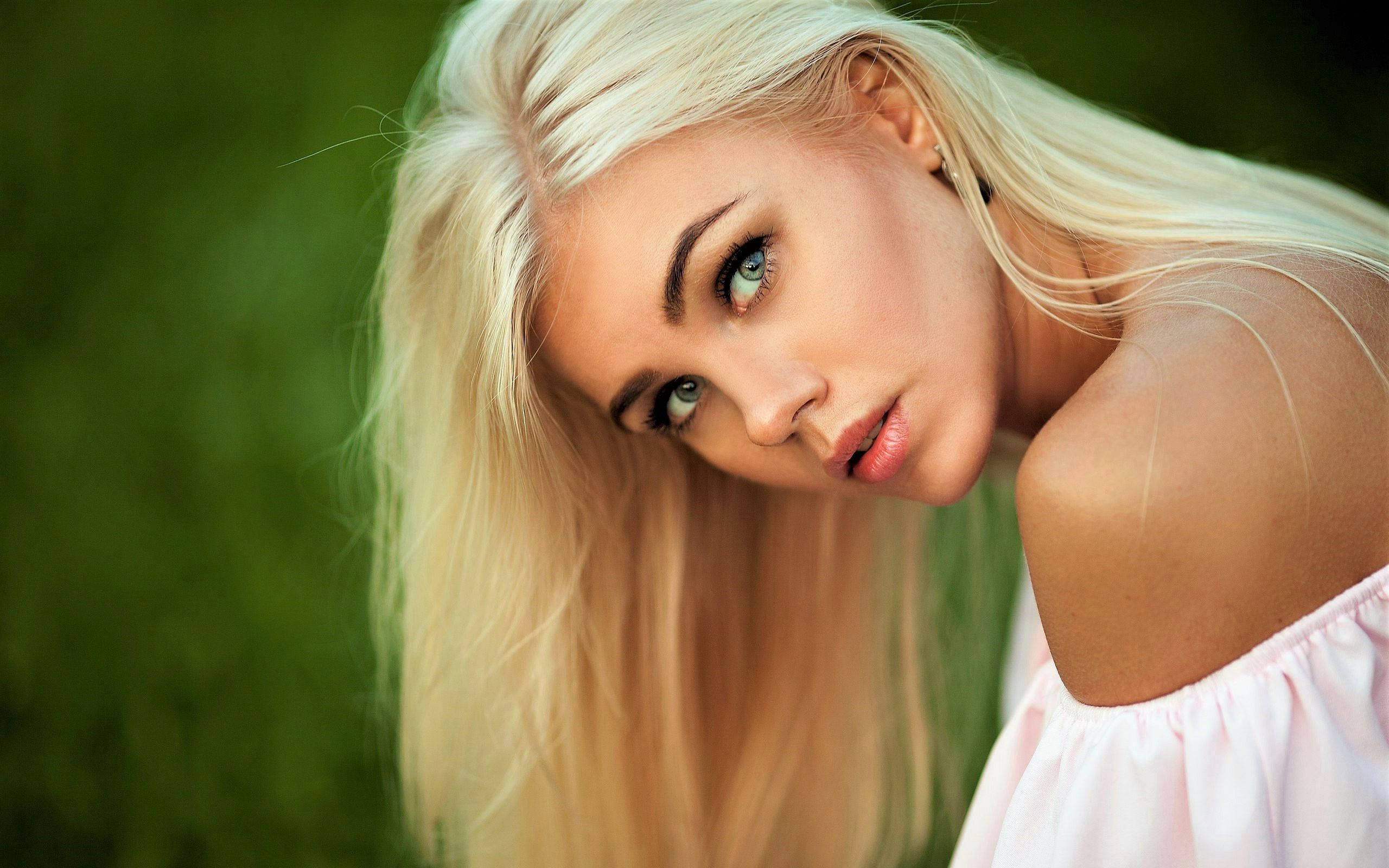 blonde woman, striking blue eyes, soft green blurred background, 2K Desktop Wallpaper