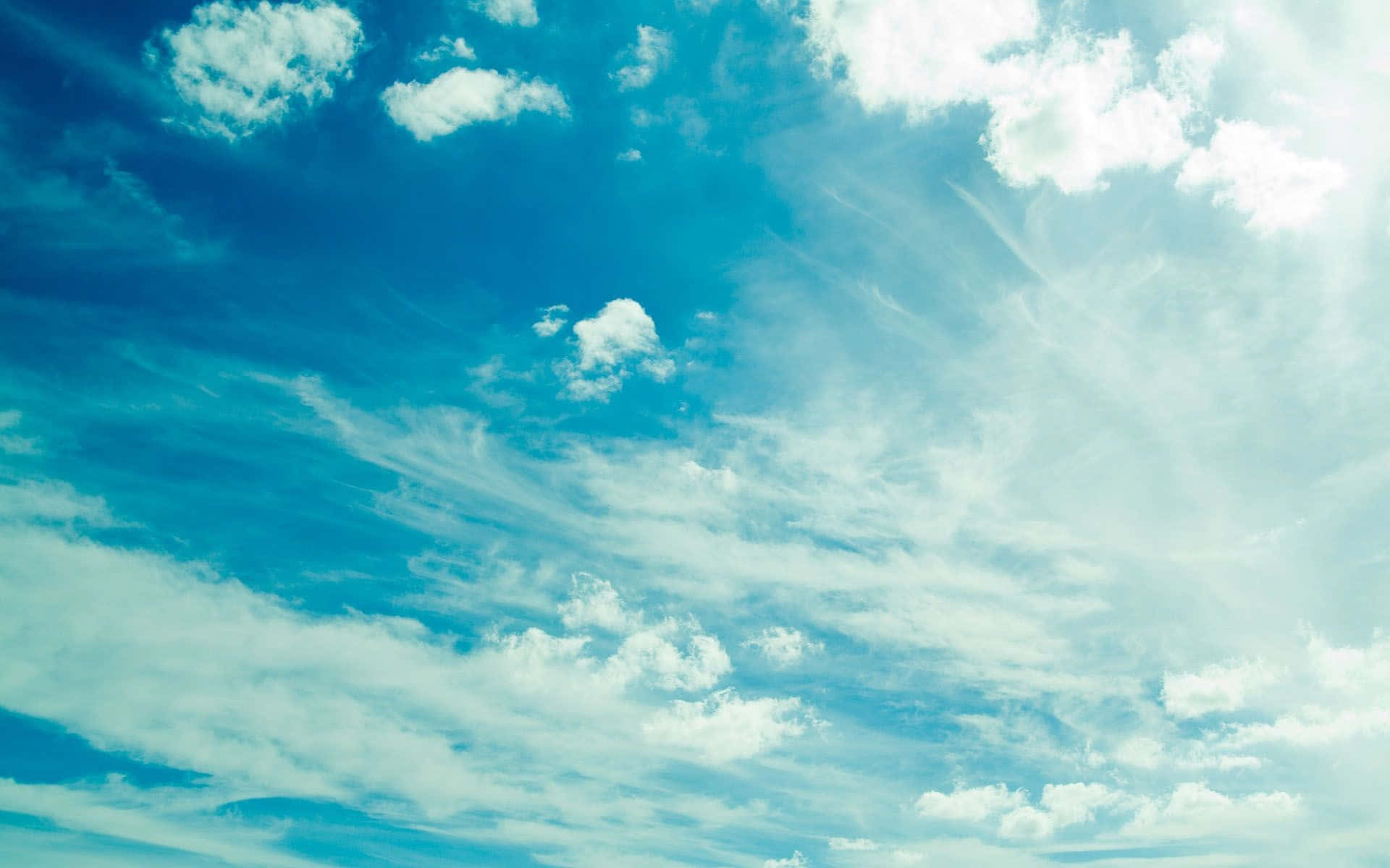 Vibrant blue sky, wispy white clouds, soft sun rays, Full HD Desktop Wallpaper