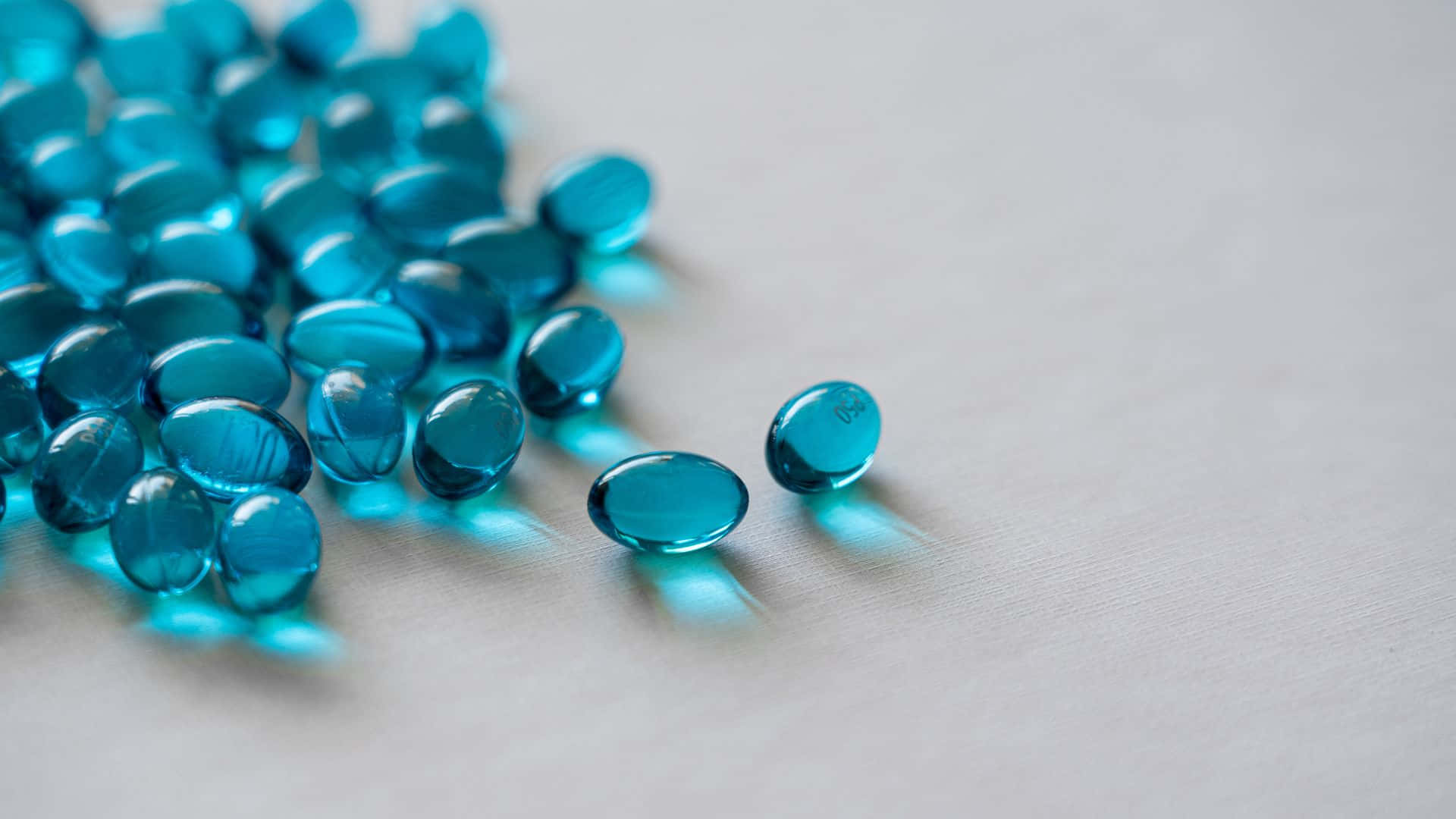 blue gel capsules, translucent blue gel capsules, soft gray surface, Full HD Desktop Wallpaper