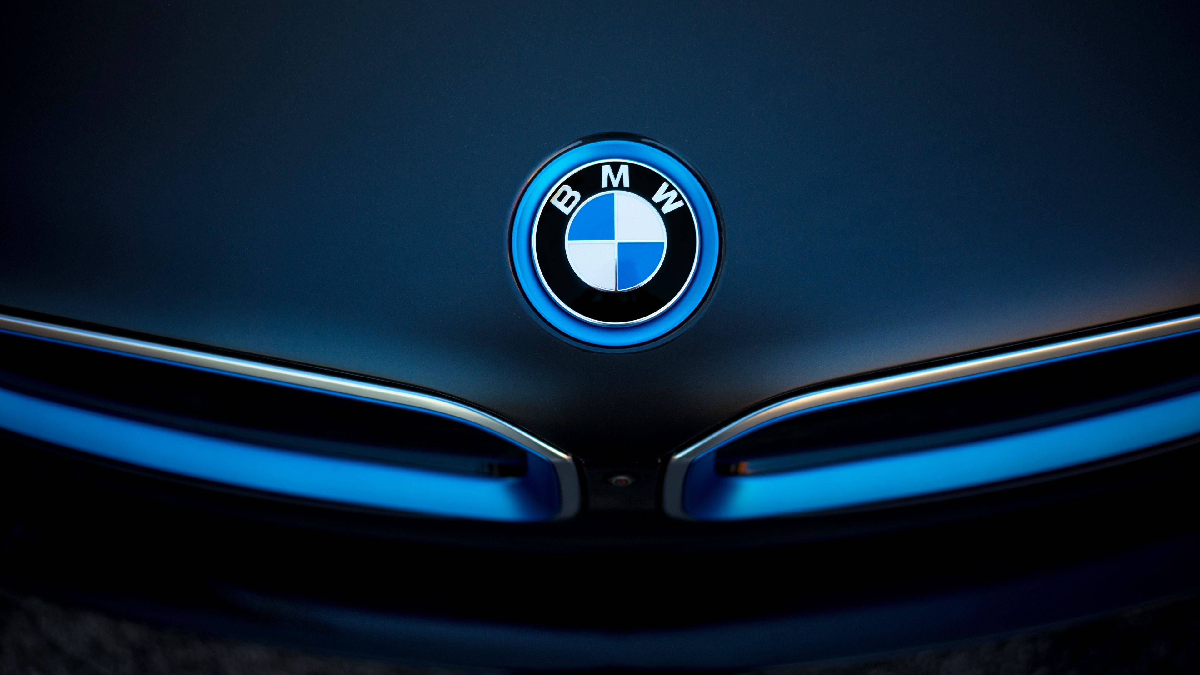 BMW, glowing blue BMW logo, sleek dark car hood, 4K Desktop Wallpaper