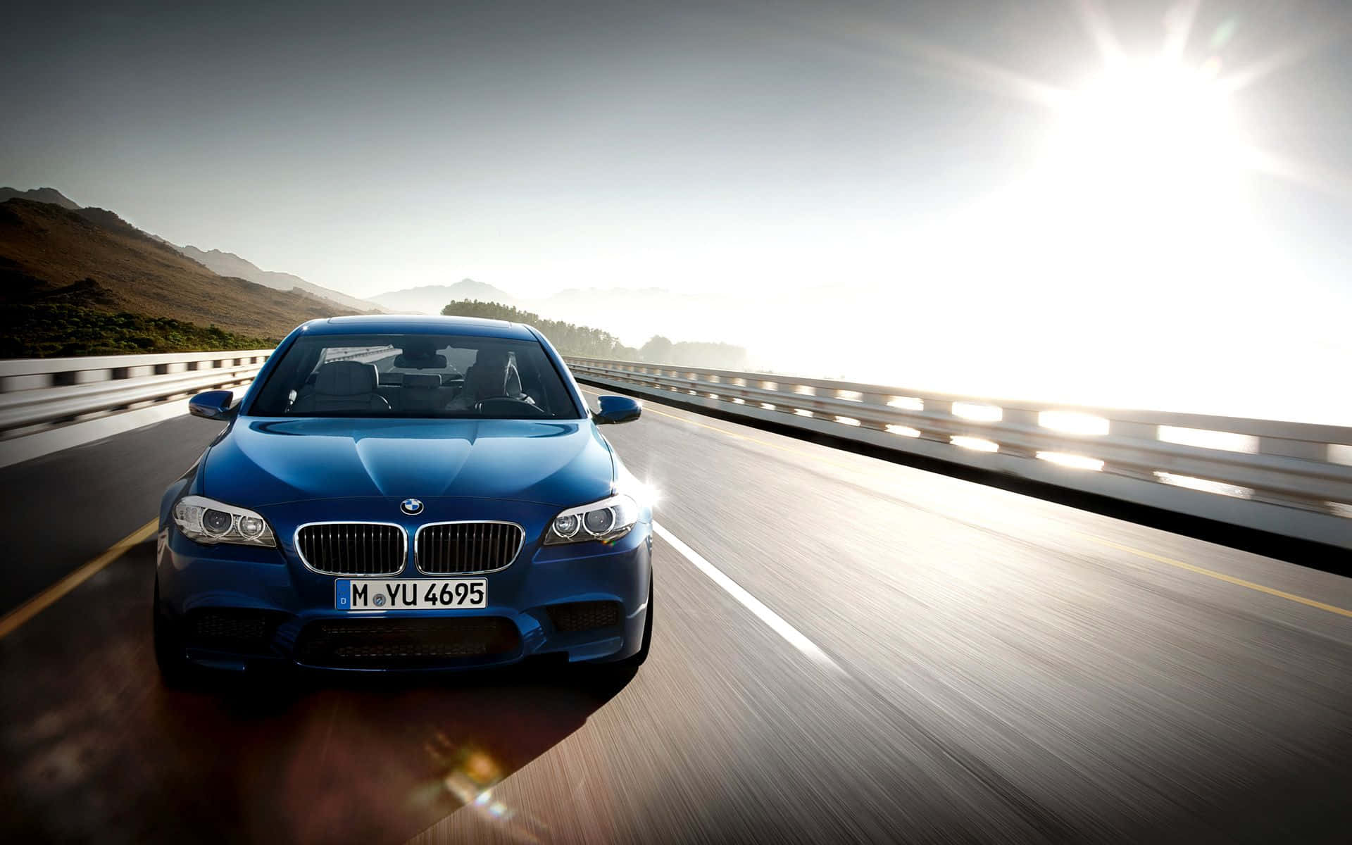 BMW M5, vibrant blue, sun-drenched mountain highway, Full HD Desktop Wallpaper
