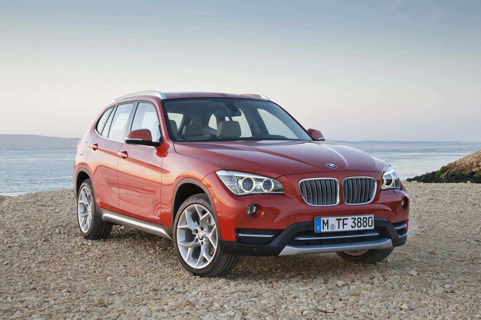 BMW X1, glossy red, pebbled beach, HD Desktop Wallpaper