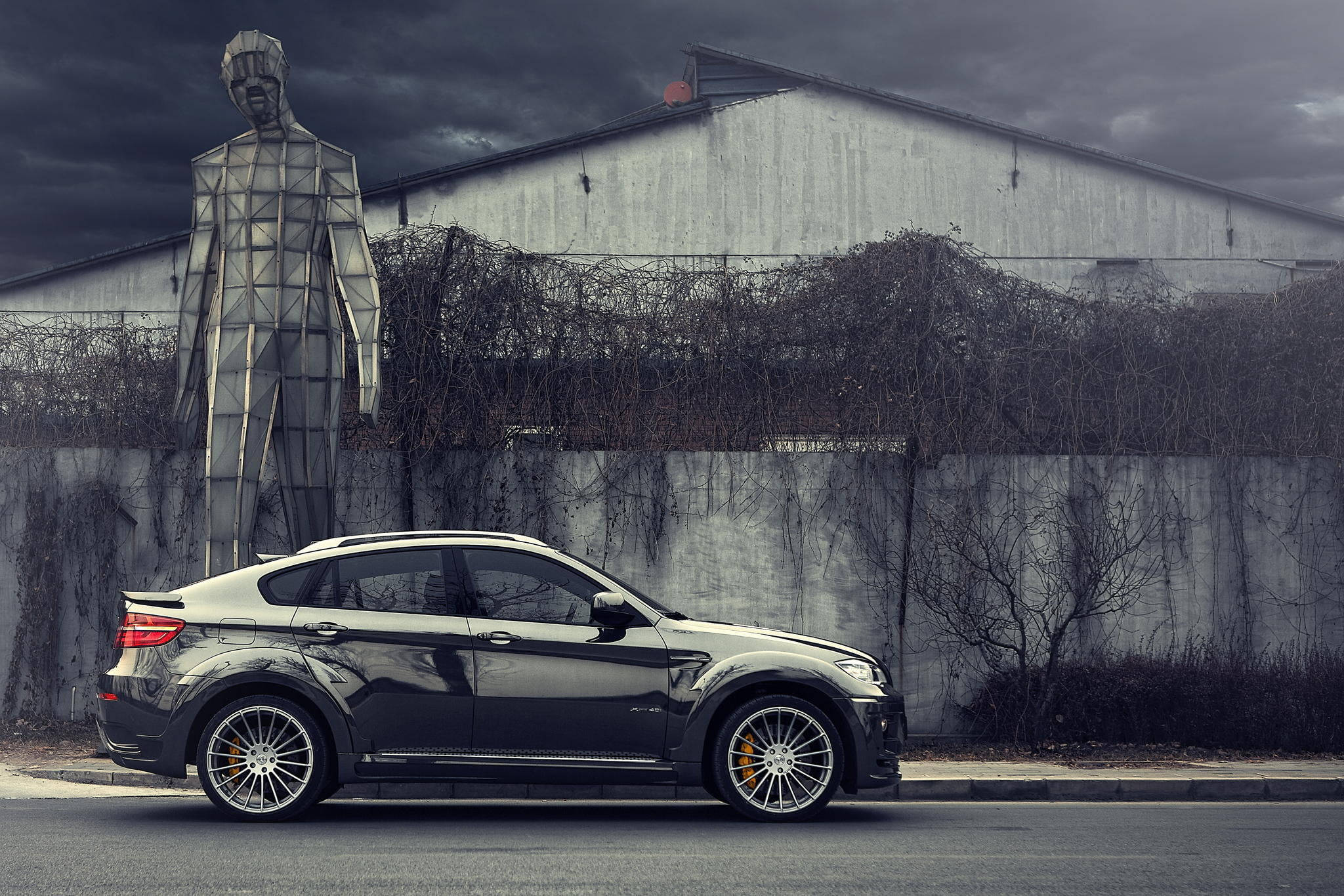 BMW X6 M, sleek black, towering geometric human statue, Full HD Desktop Wallpaper