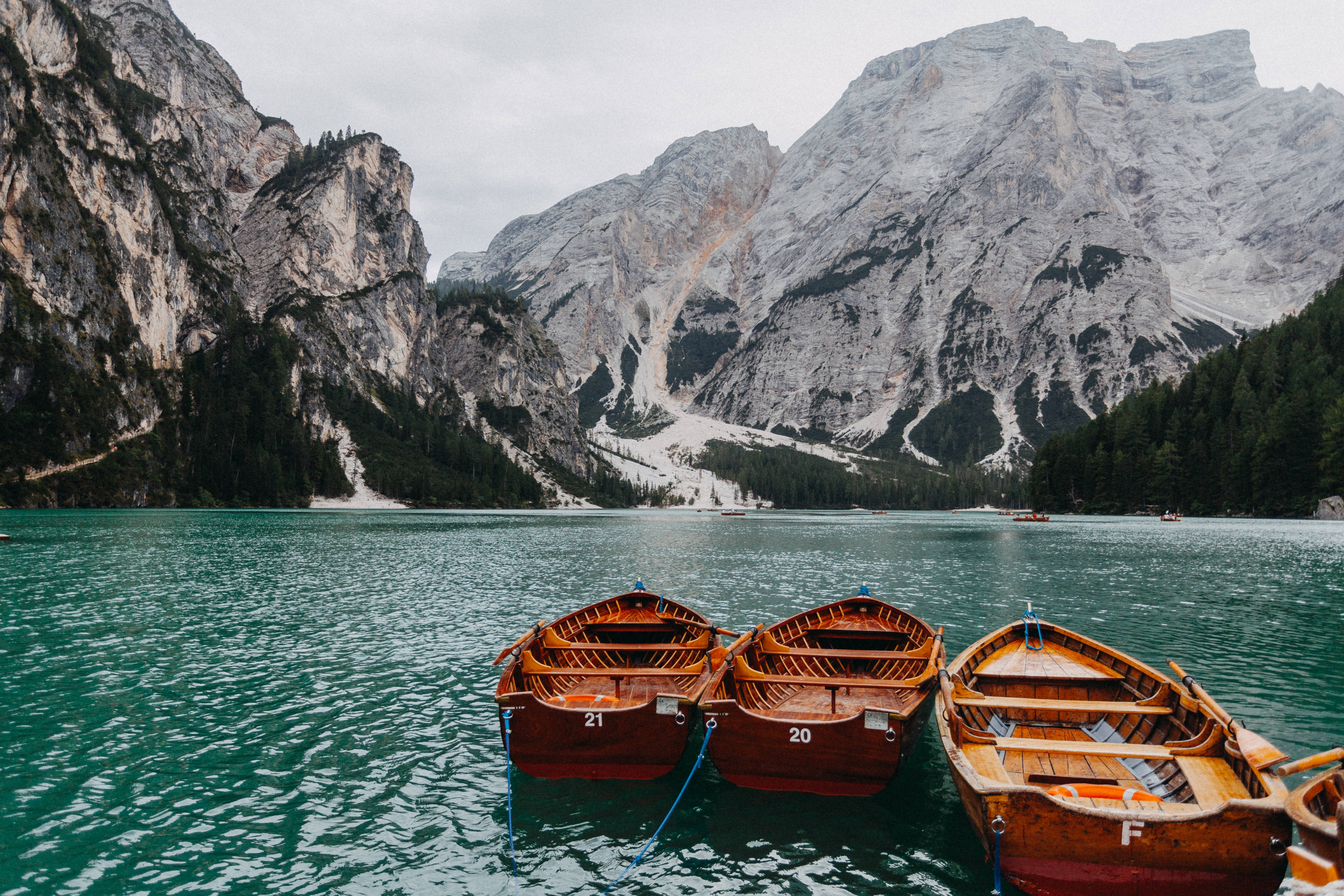 three wooden boats, turquoise lake, towering rocky mountains, 5K Desktop Wallpaper